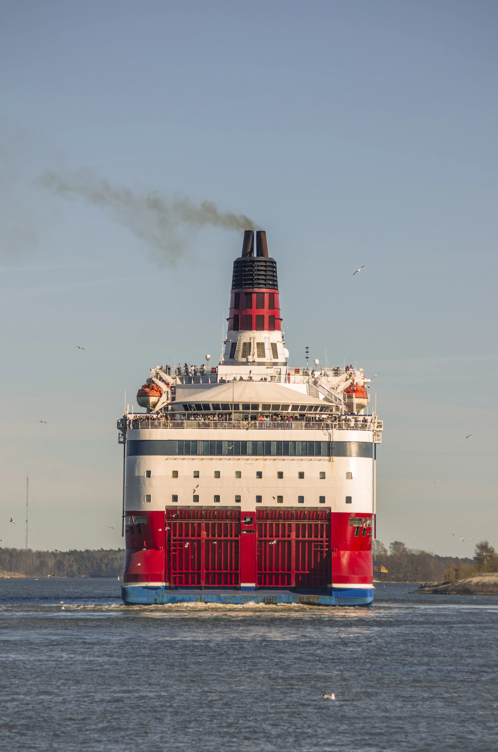Large red and white ferry boat sailing on the water