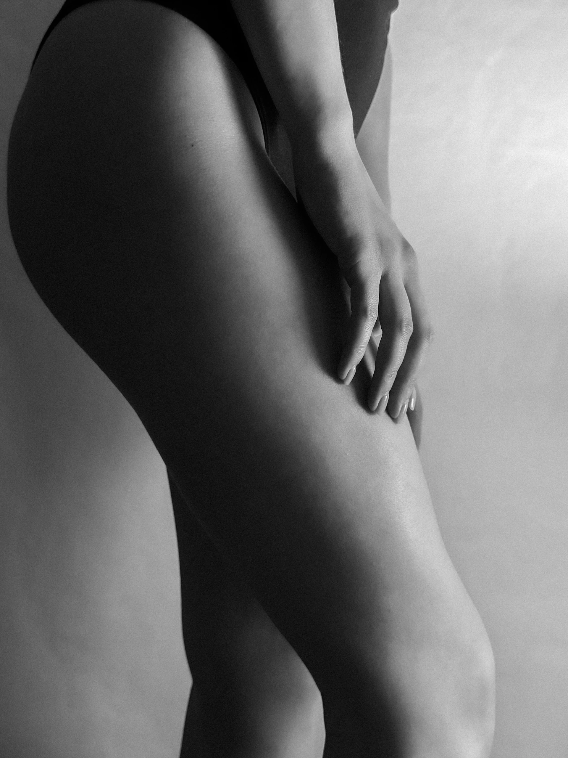 A woman's legs and hand in black and white