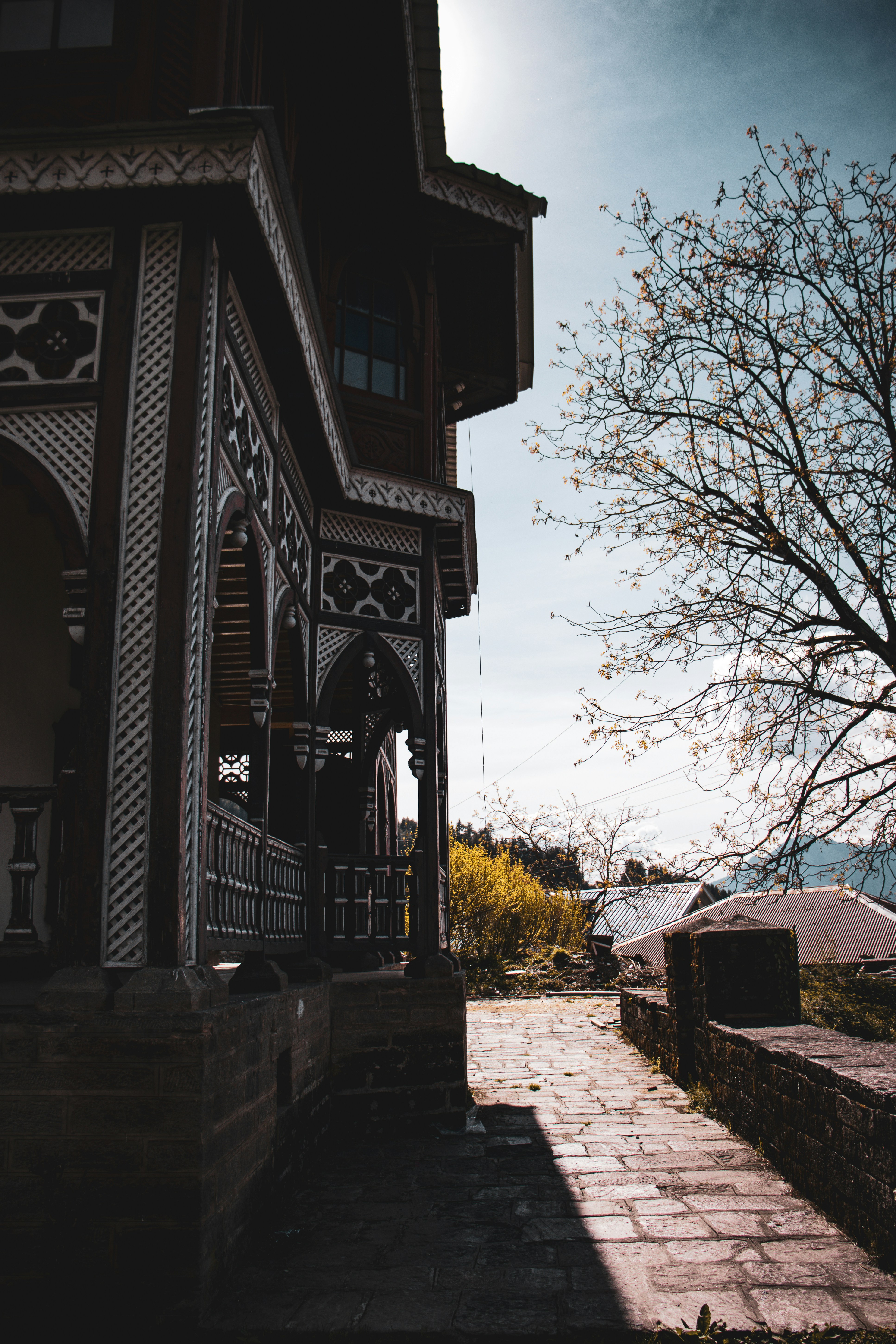 Intricate traditional building facade with a stone path and tree