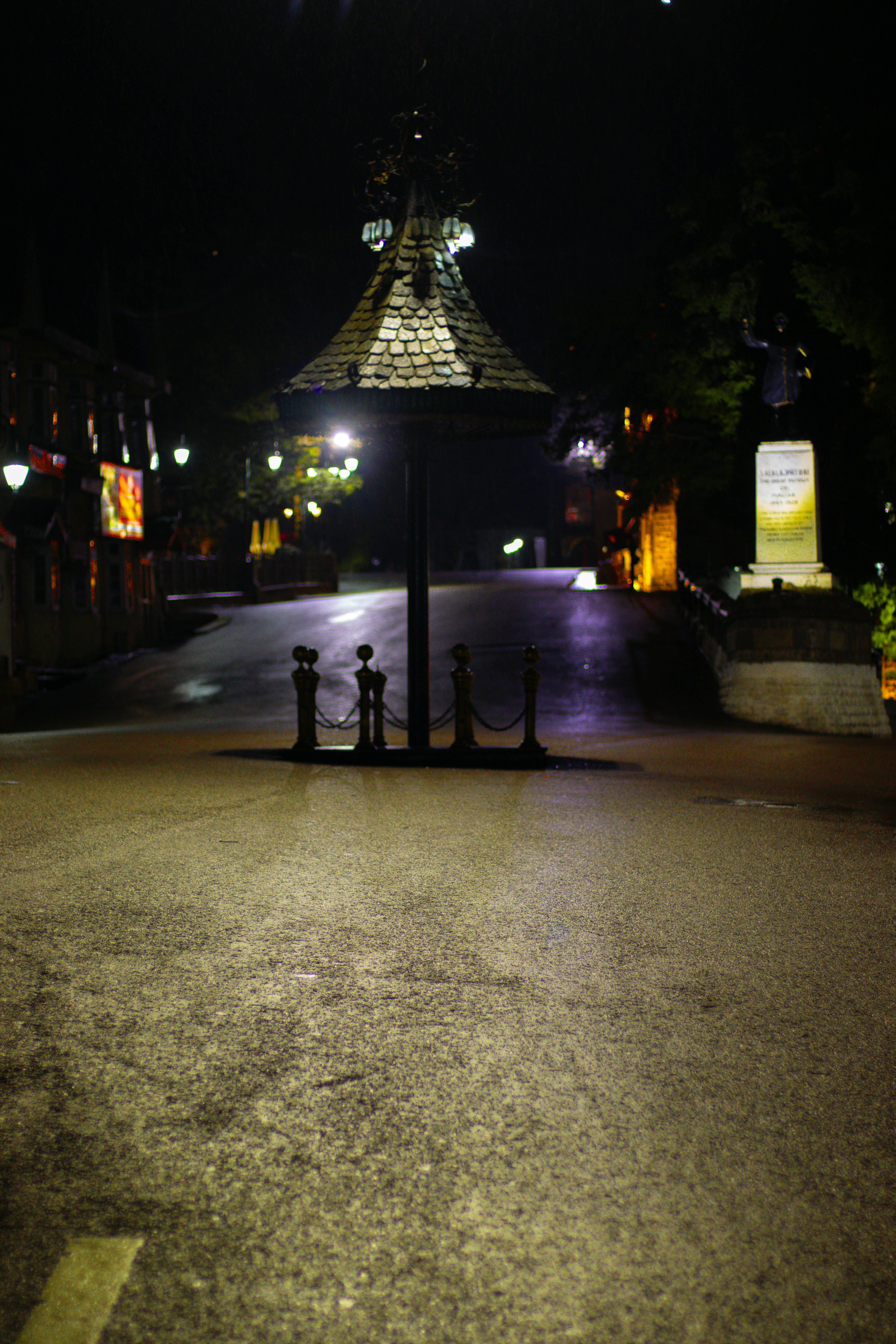 Lit pagoda-like structure on a dark street at night
