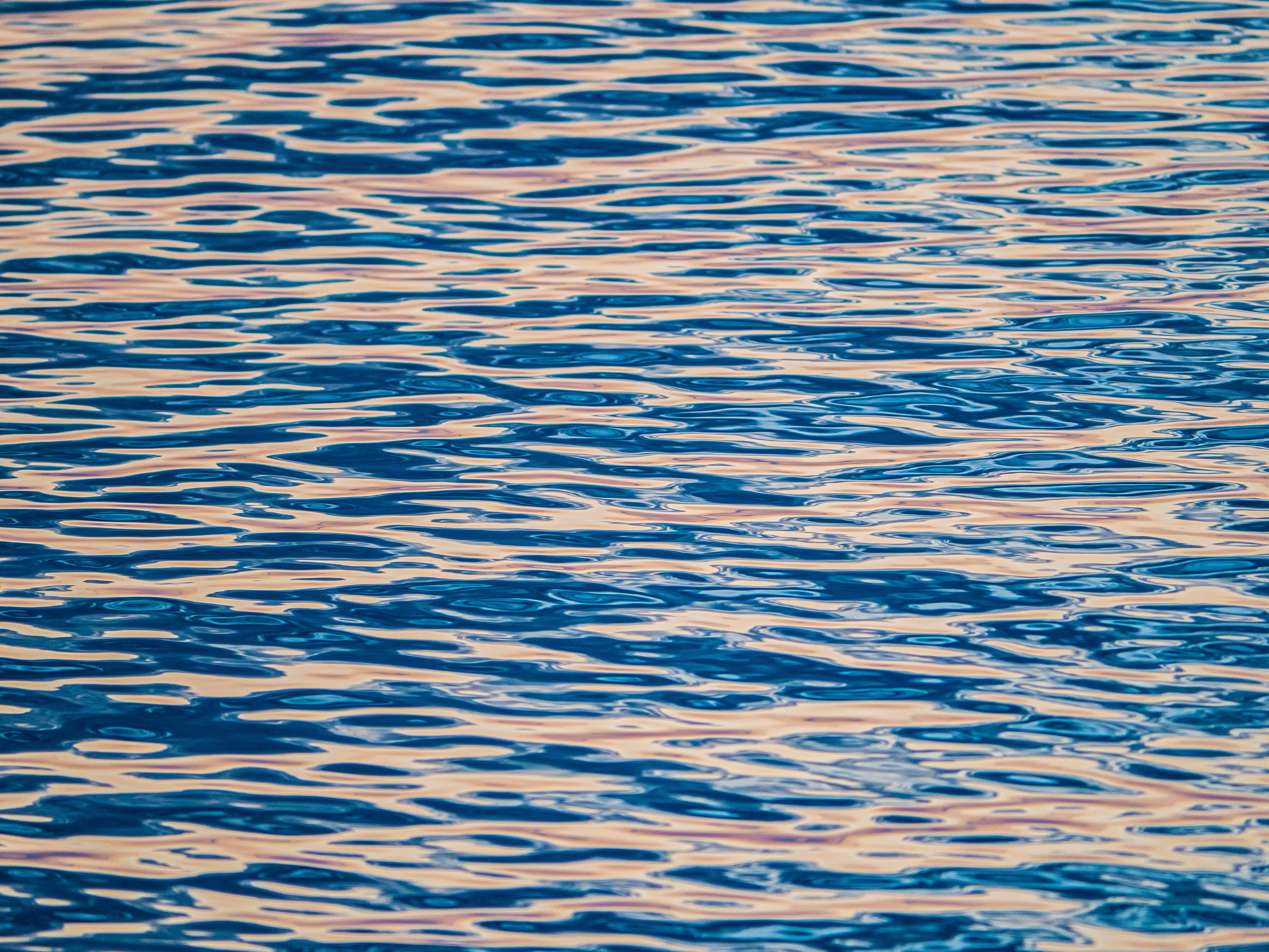 Agua azul ondulante con reflejos de luz dorada