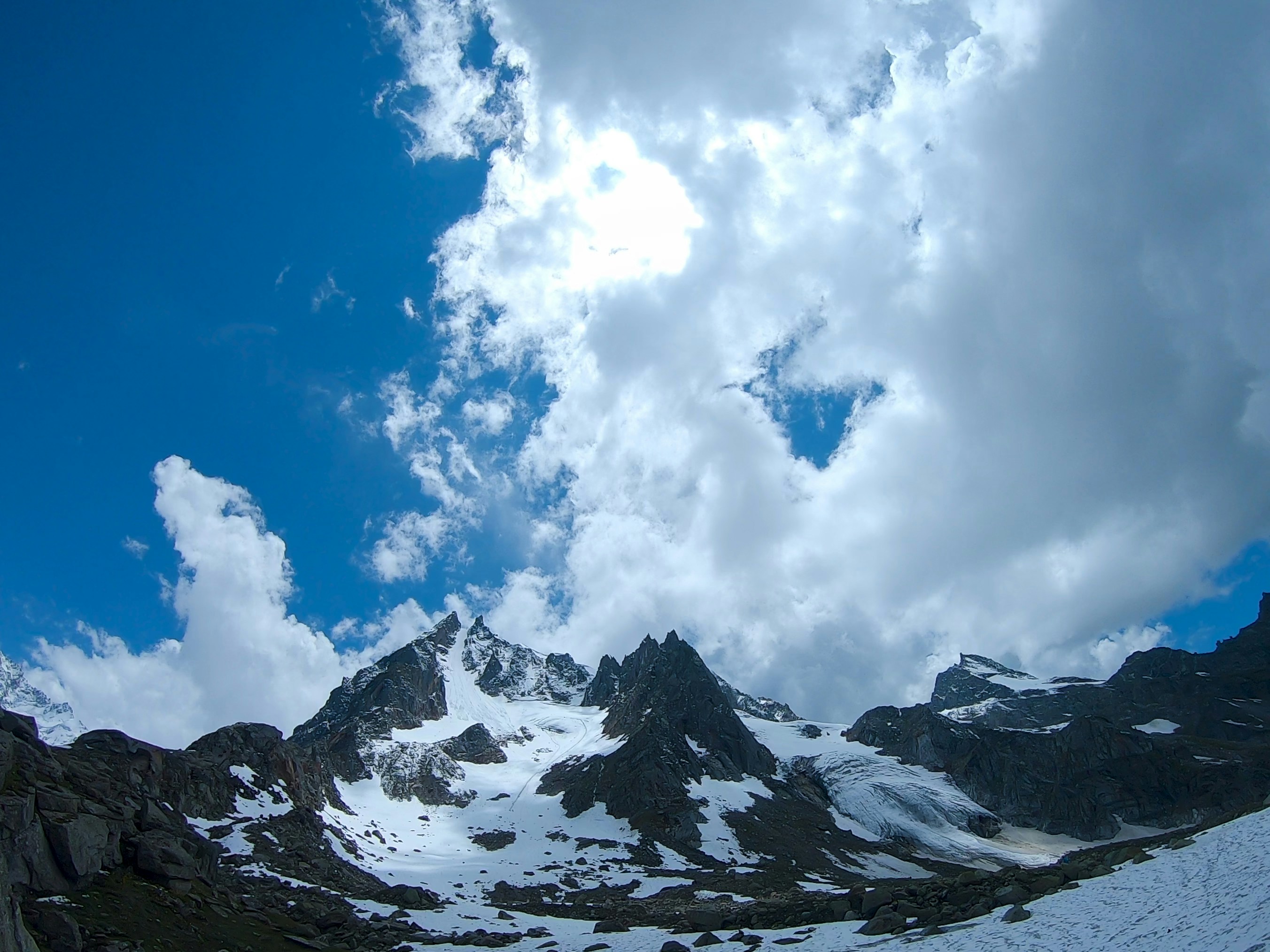 Snow-capped mountains under a dramatic cloudy sky