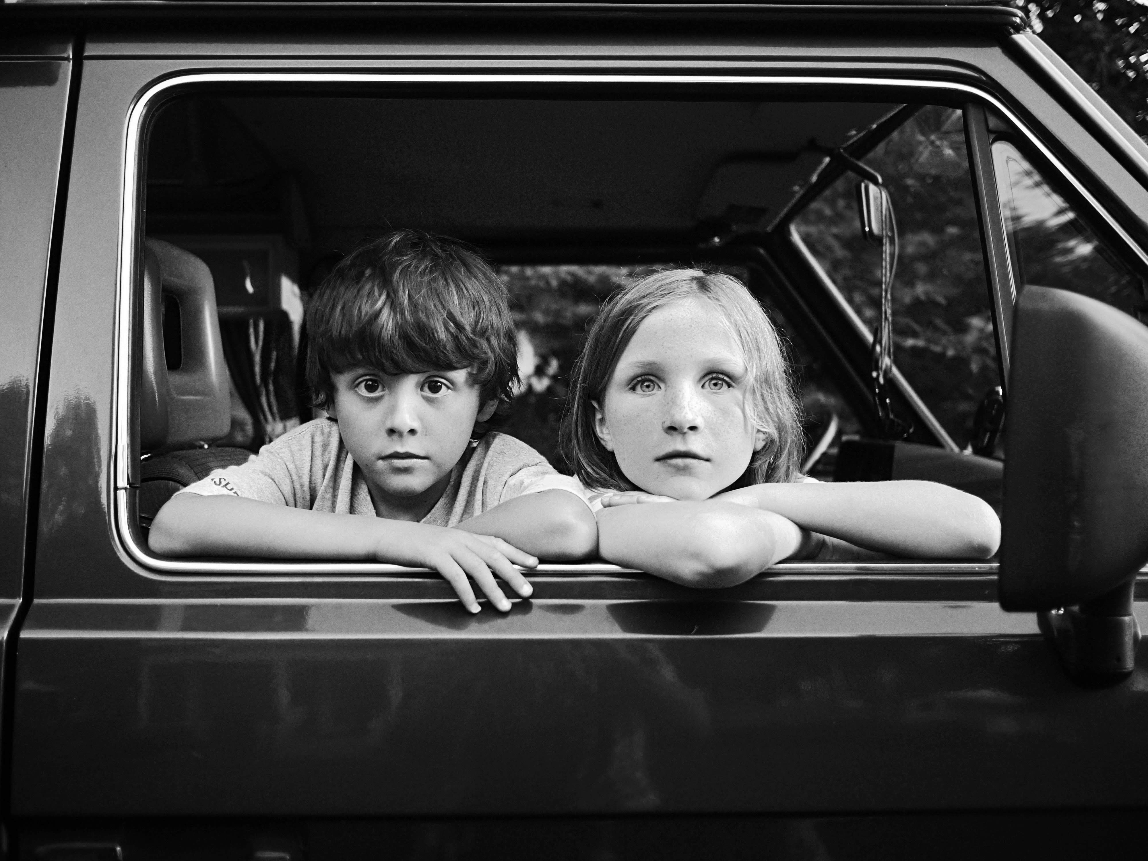 Two children look out of a car window