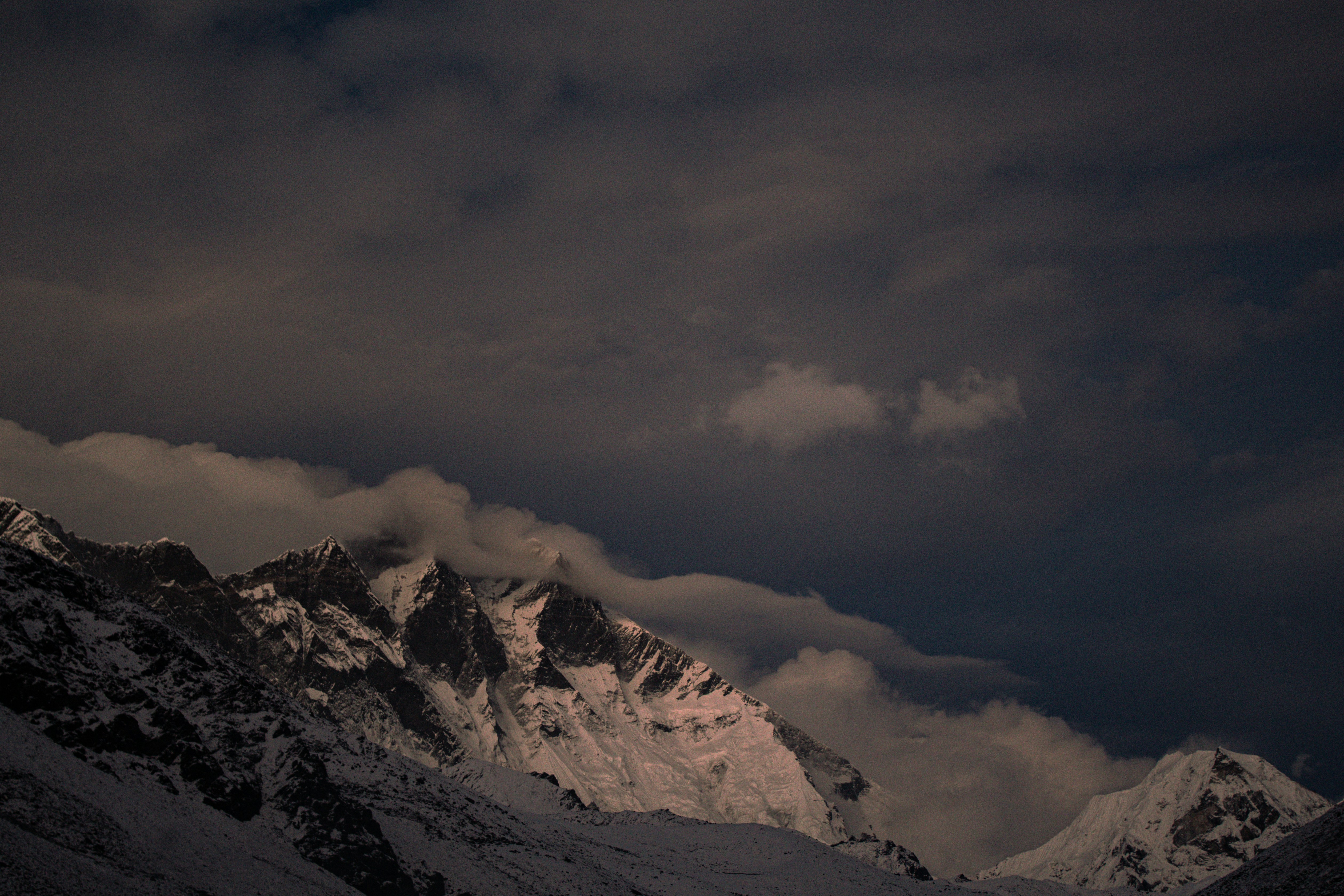 Montagnes enneigées sous des nuages spectaculaires au coucher du soleil
