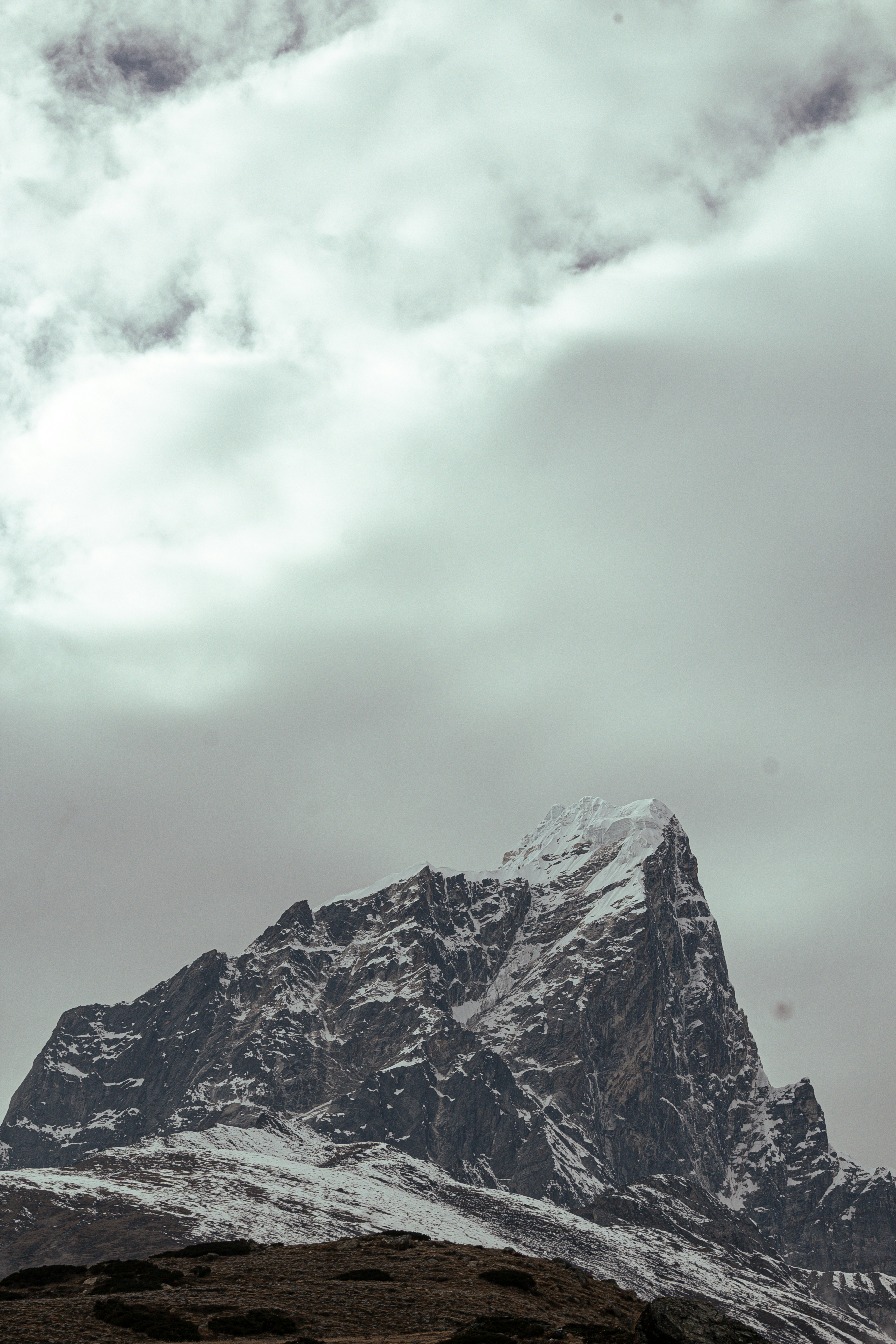 Sommet de montagne enneigé sous un ciel nuageux