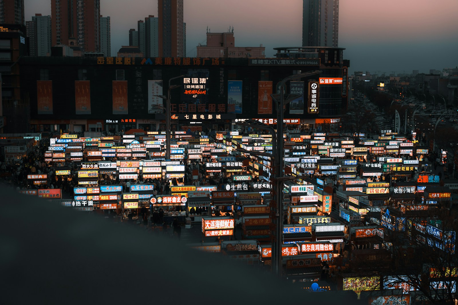 Vue panoramique d'une ville la nuit saturée d'enseignes commerciales lumineuses illustrant un marché B2B encombré