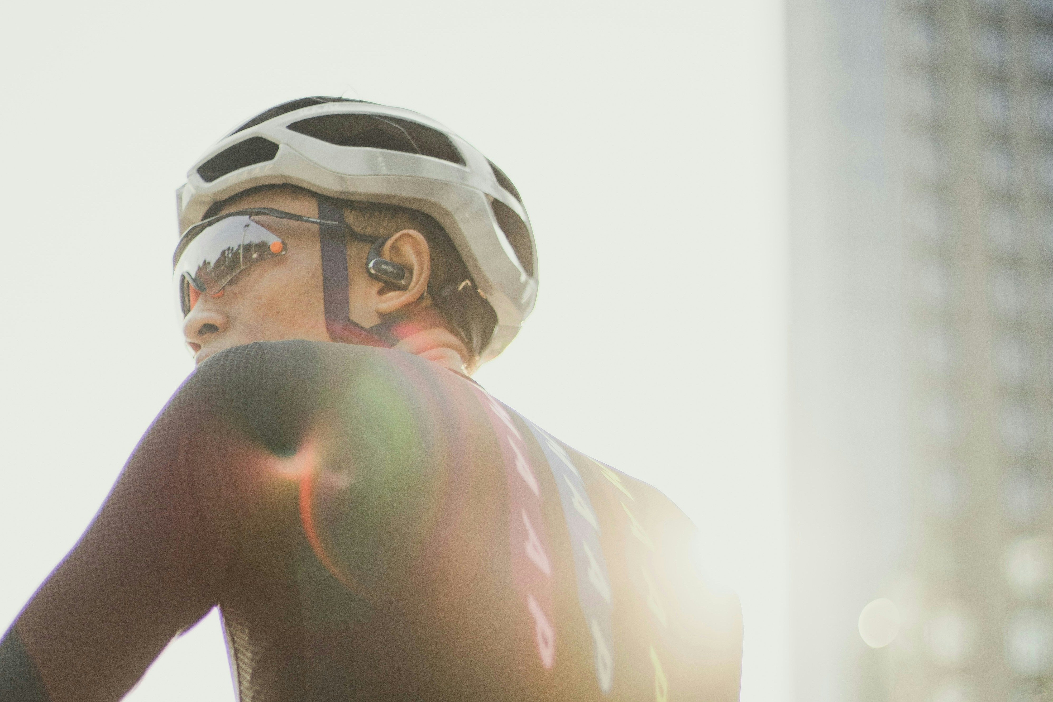 Cyclist wearing helmet and sunglasses with sun flare