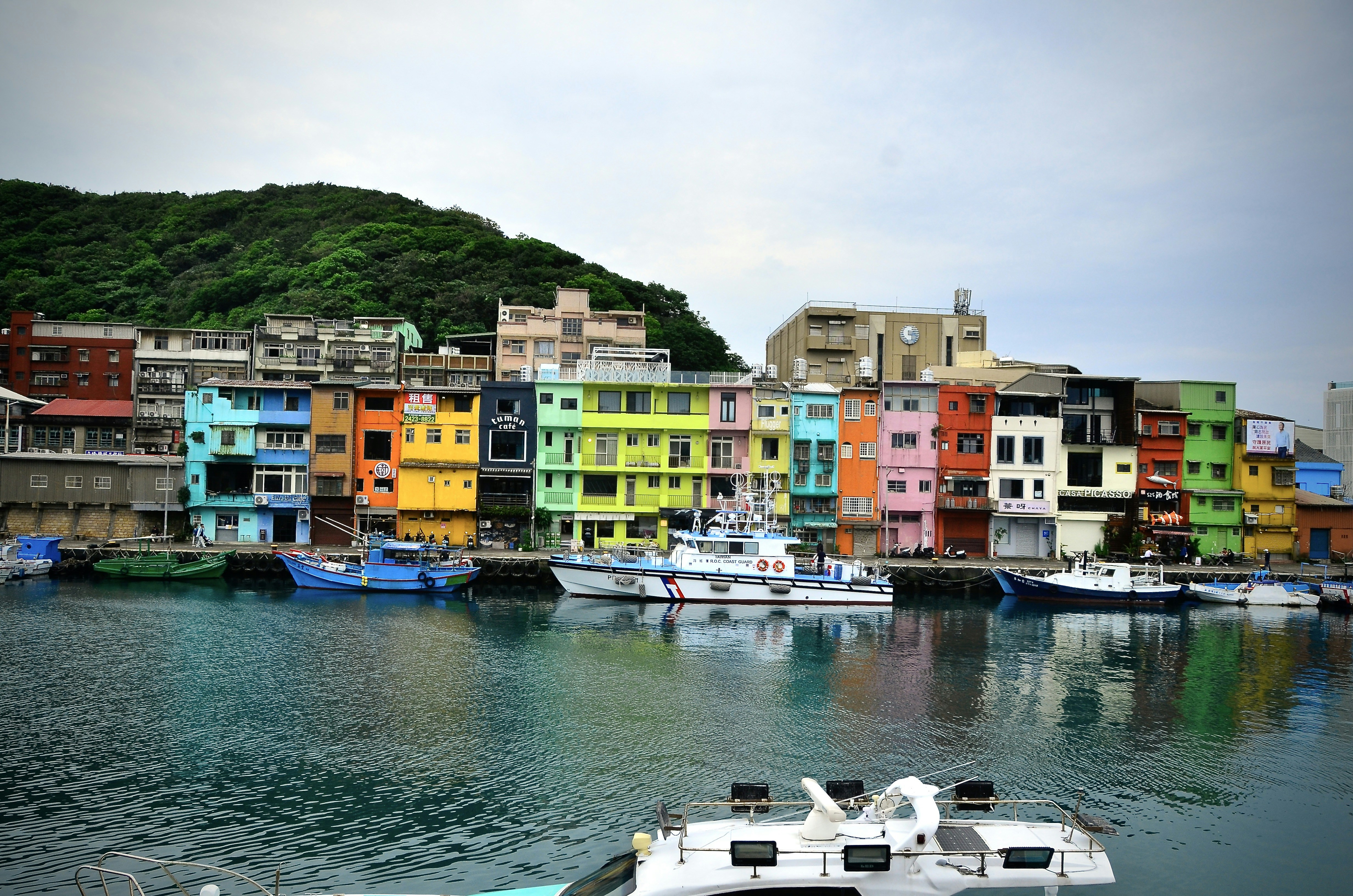 Des bâtiments colorés bordent un port de bateaux.