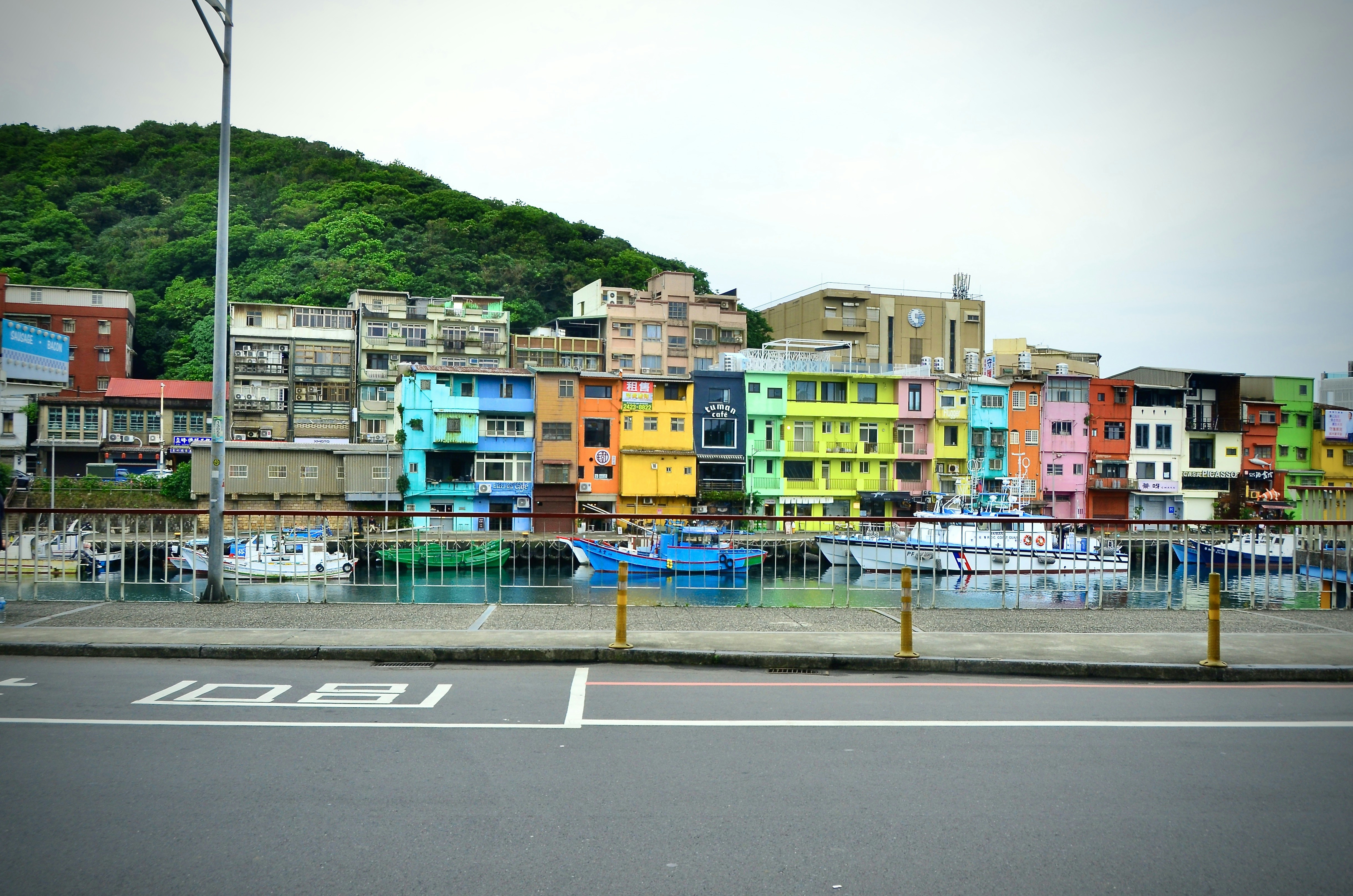 Des bâtiments colorés bordent un front de mer avec des bateaux.