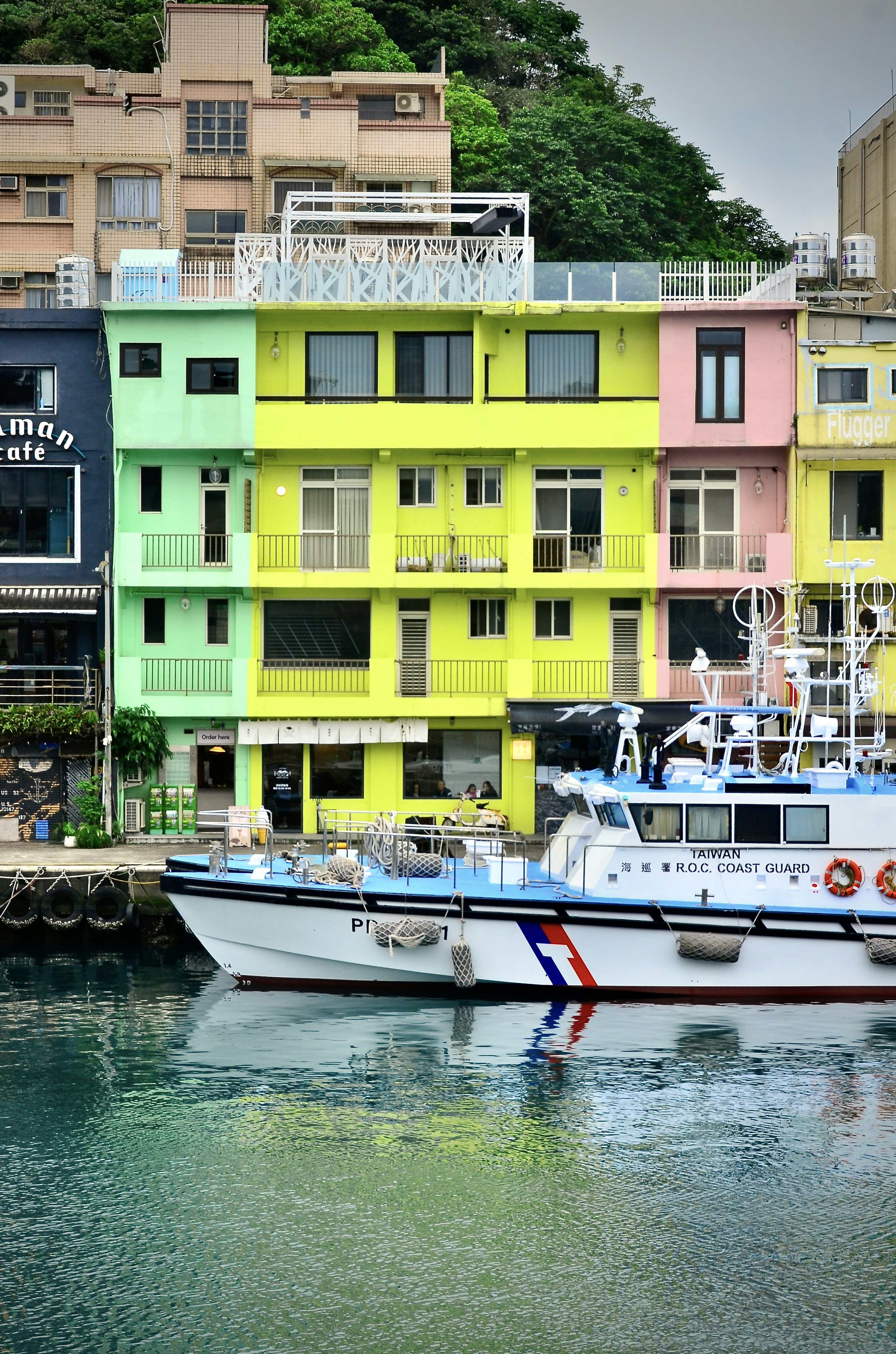 Des bâtiments colorés bordent un port avec des bateaux amarrés.