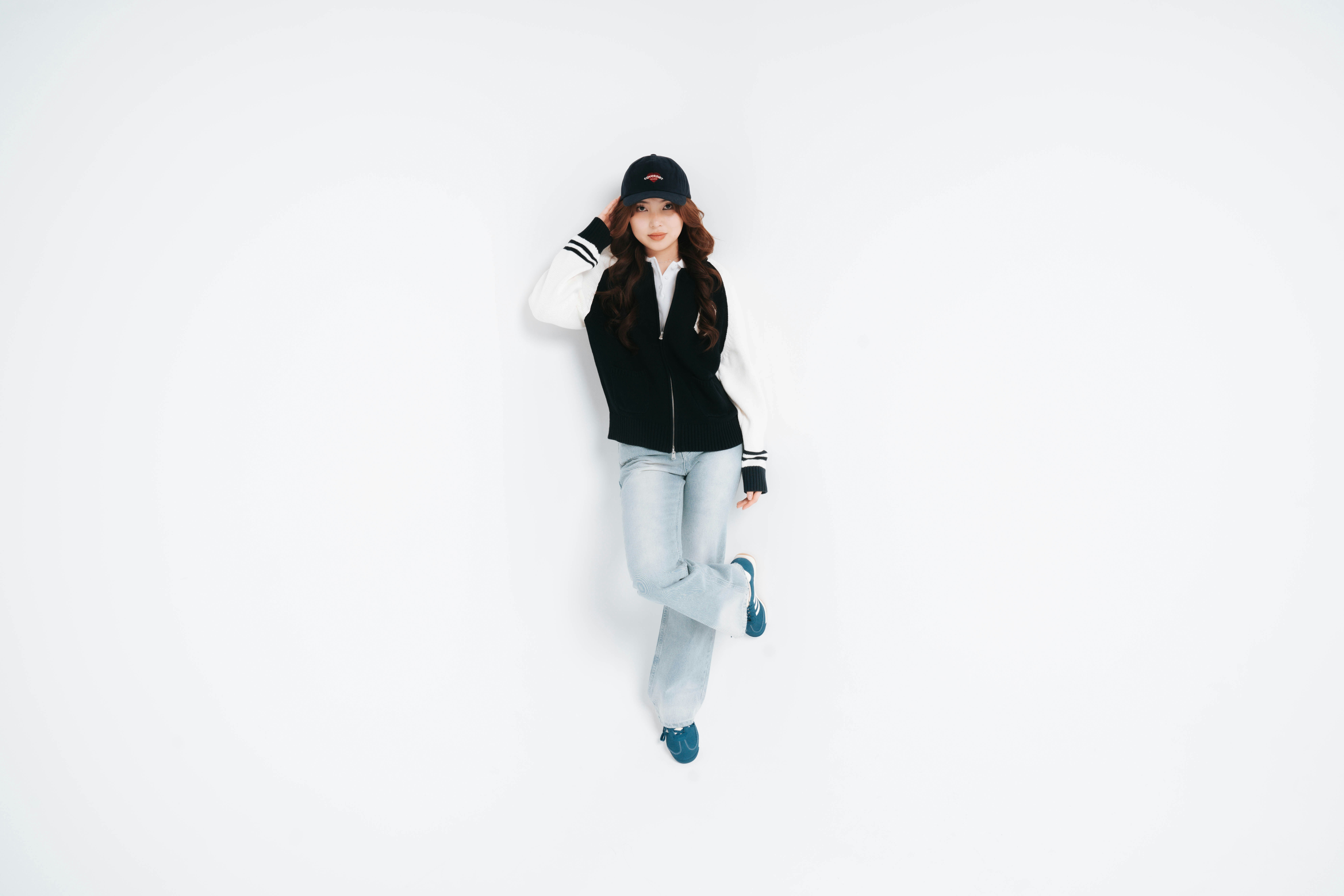 Young woman in baseball cap and varsity jacket