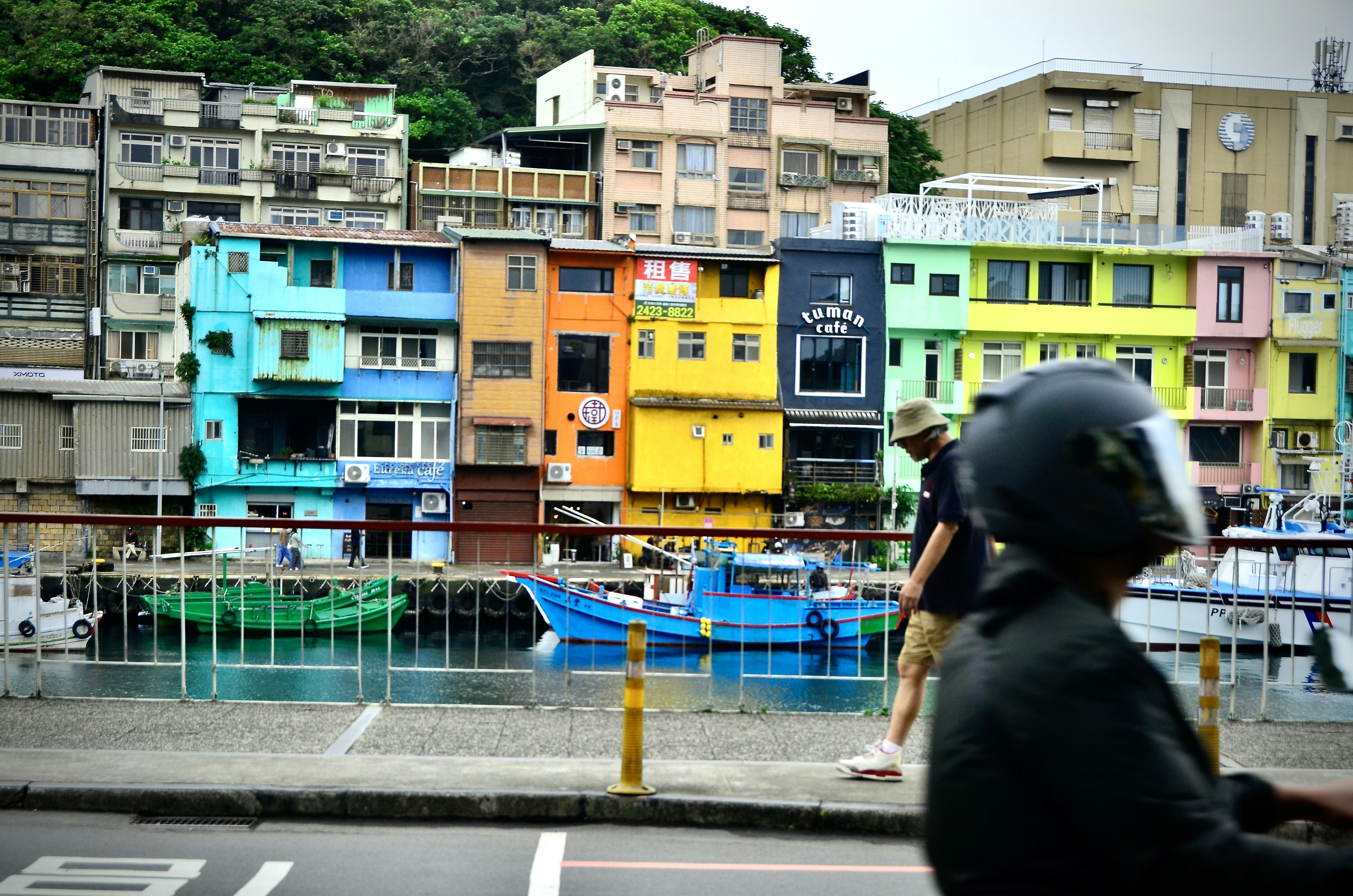 Des bâtiments colorés bordent un front de mer avec des bateaux.