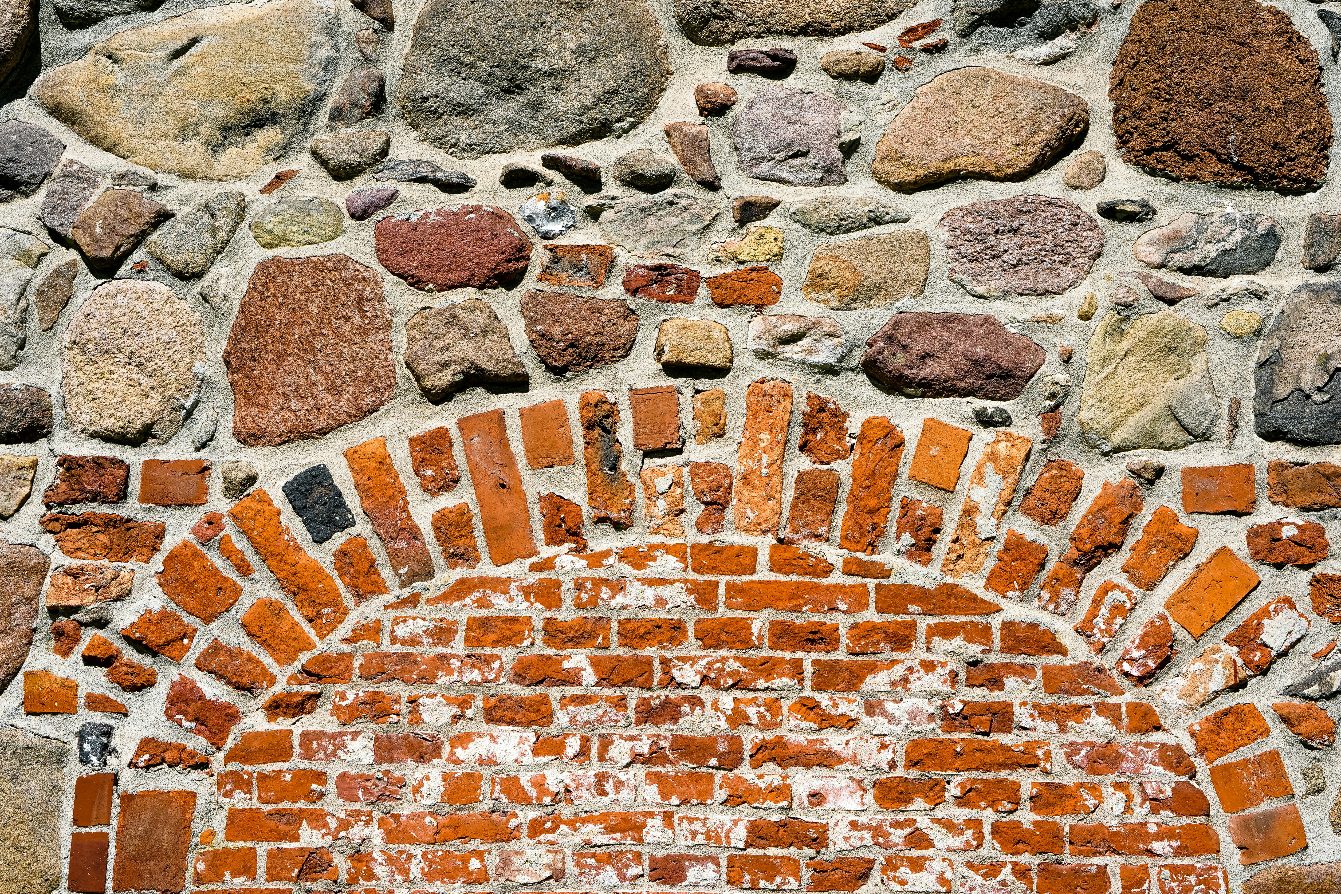 Muro de piedra tosca con arco de ladrillo