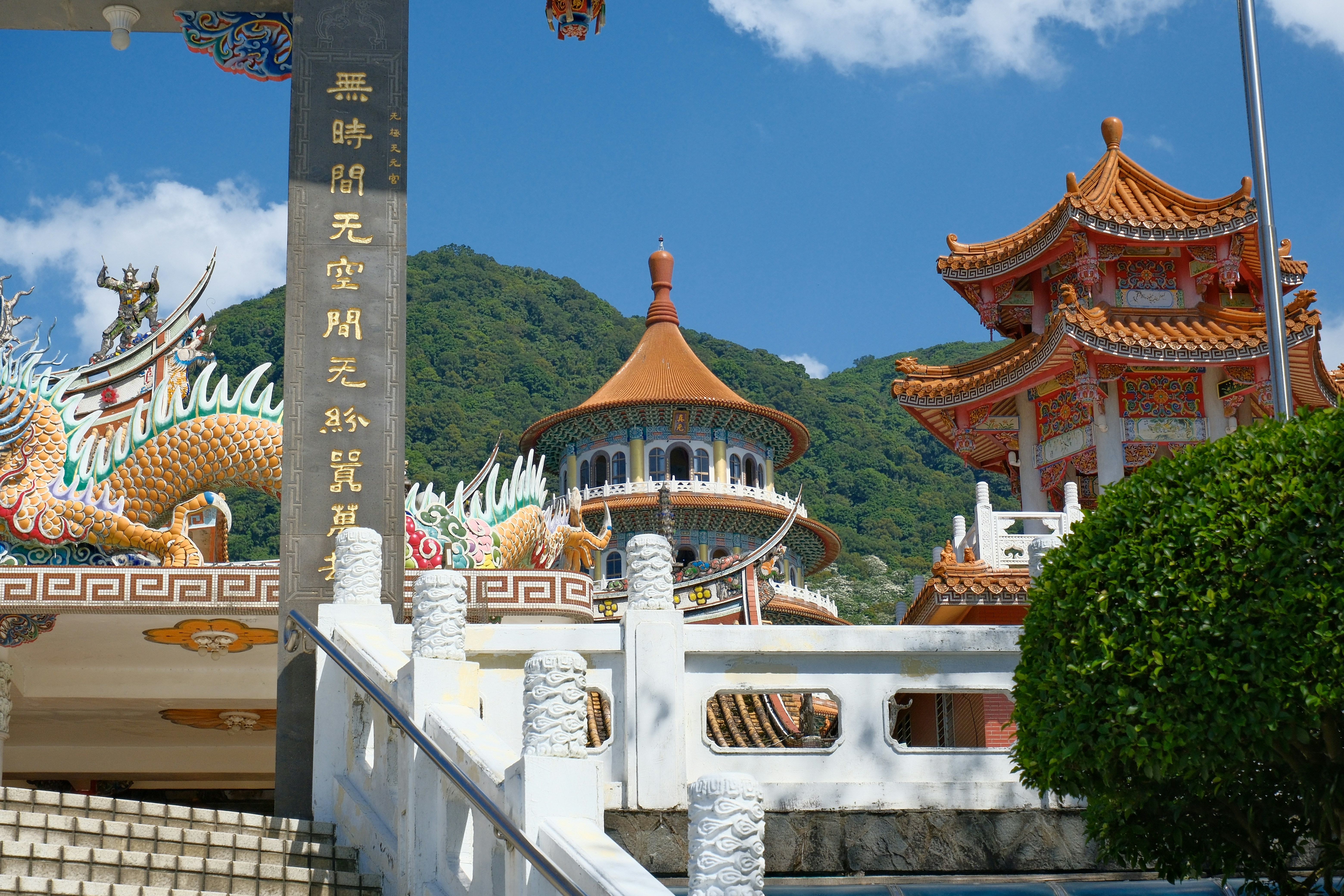 Ornate temple structures with dragon motifs and mountains