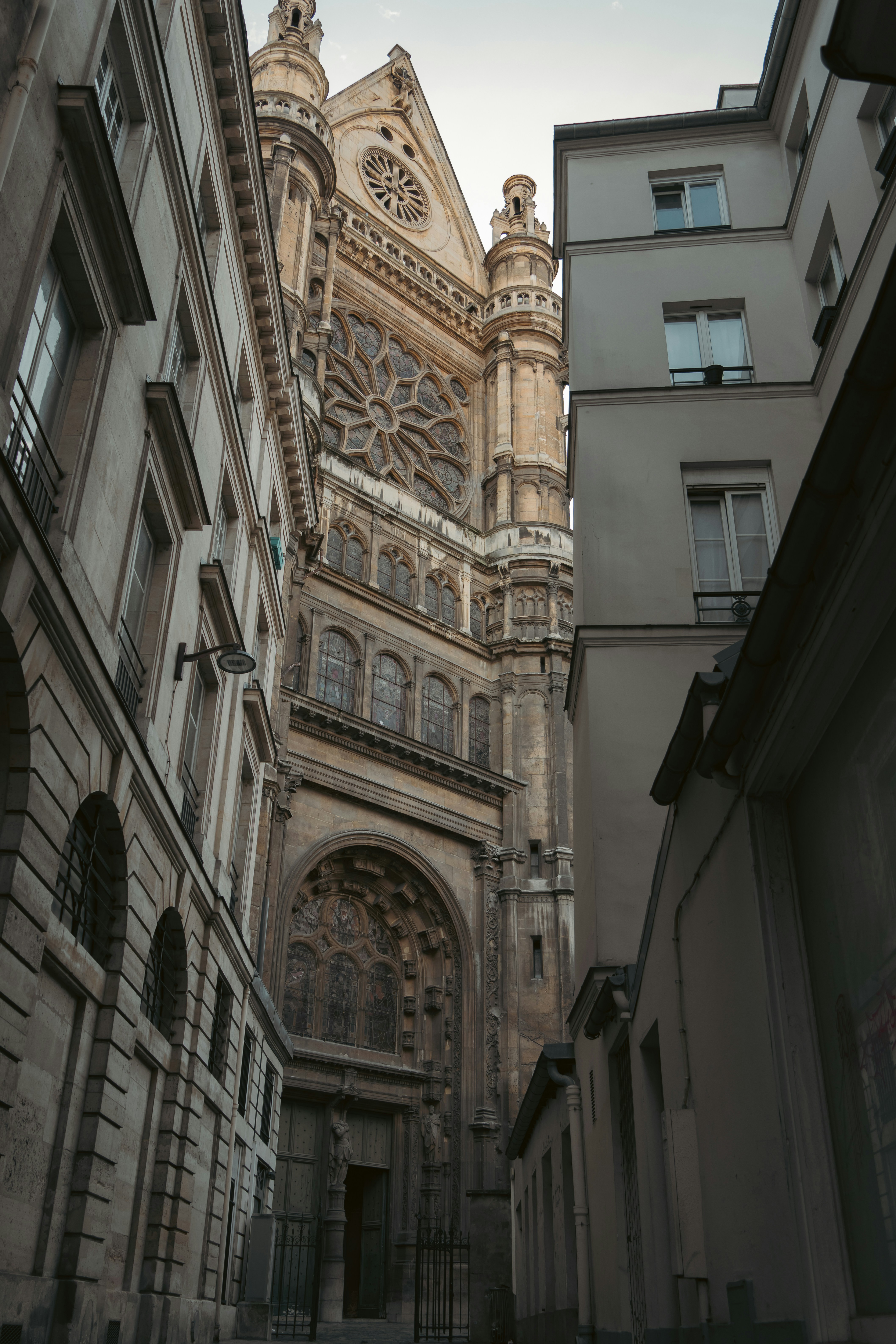 Fasad katedral gothic berornamen dilihat dari gang sempit.