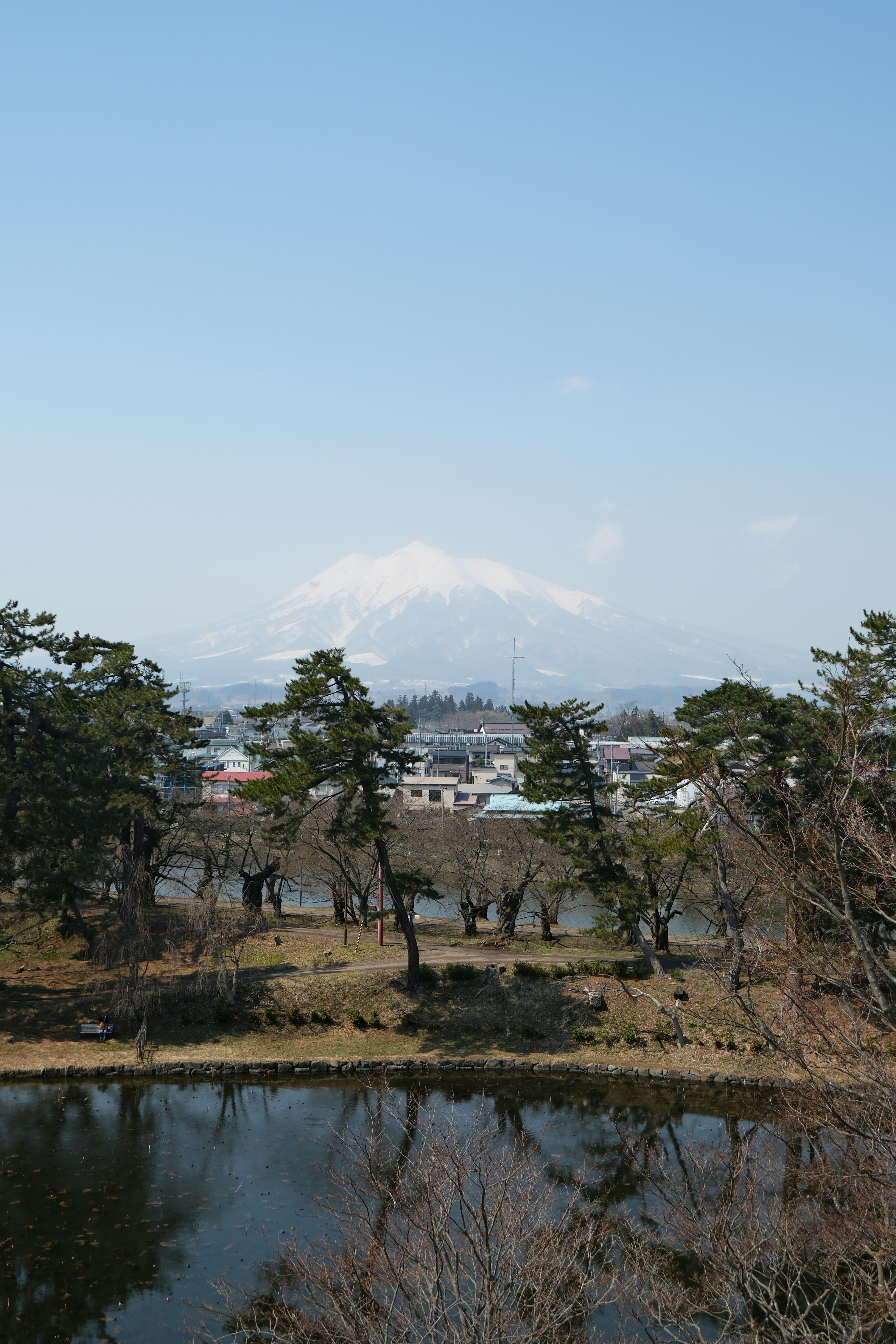Snow-capped mountain overlooks a town and lake.