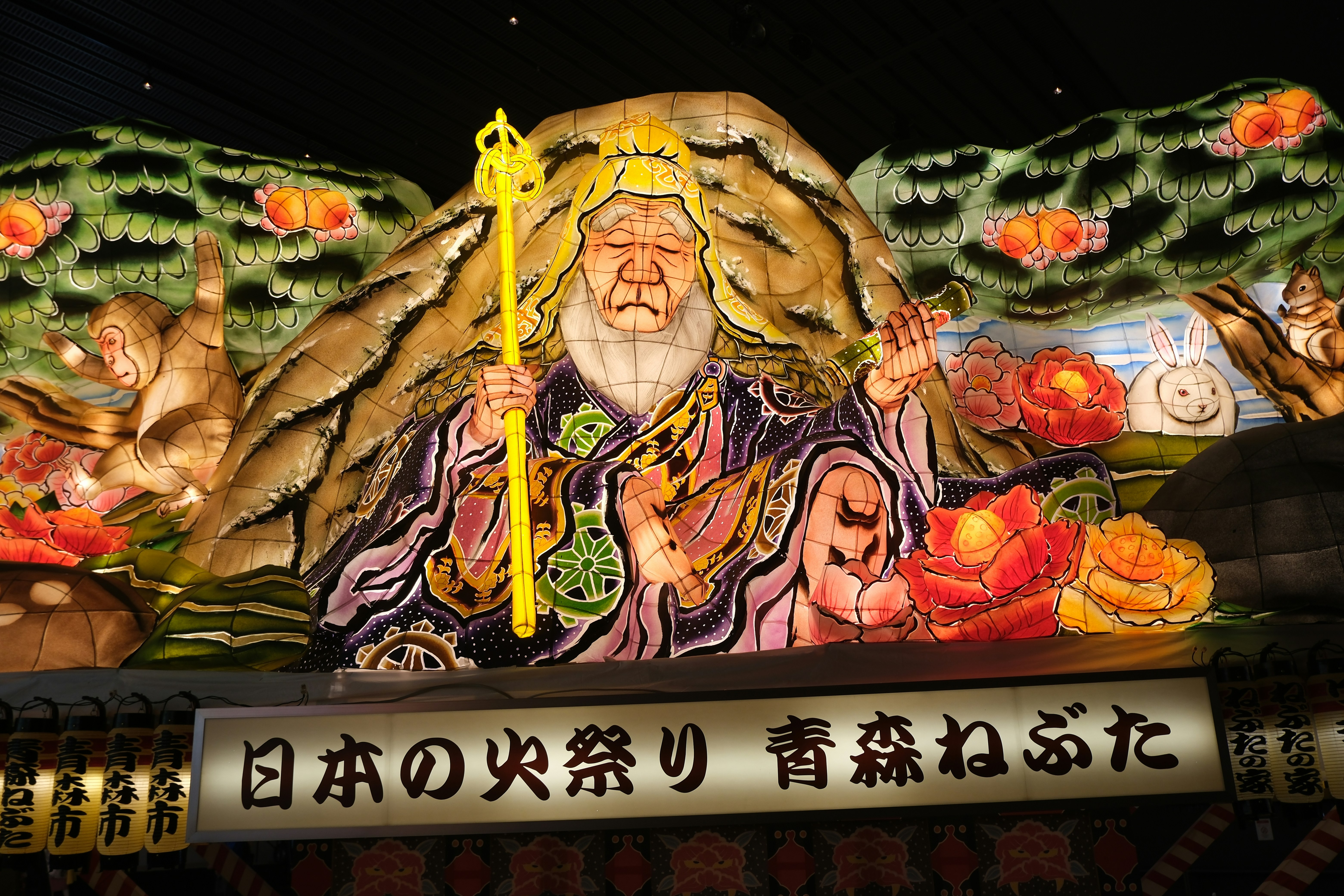 Lantern festival float with ancient figure and nature scenes.