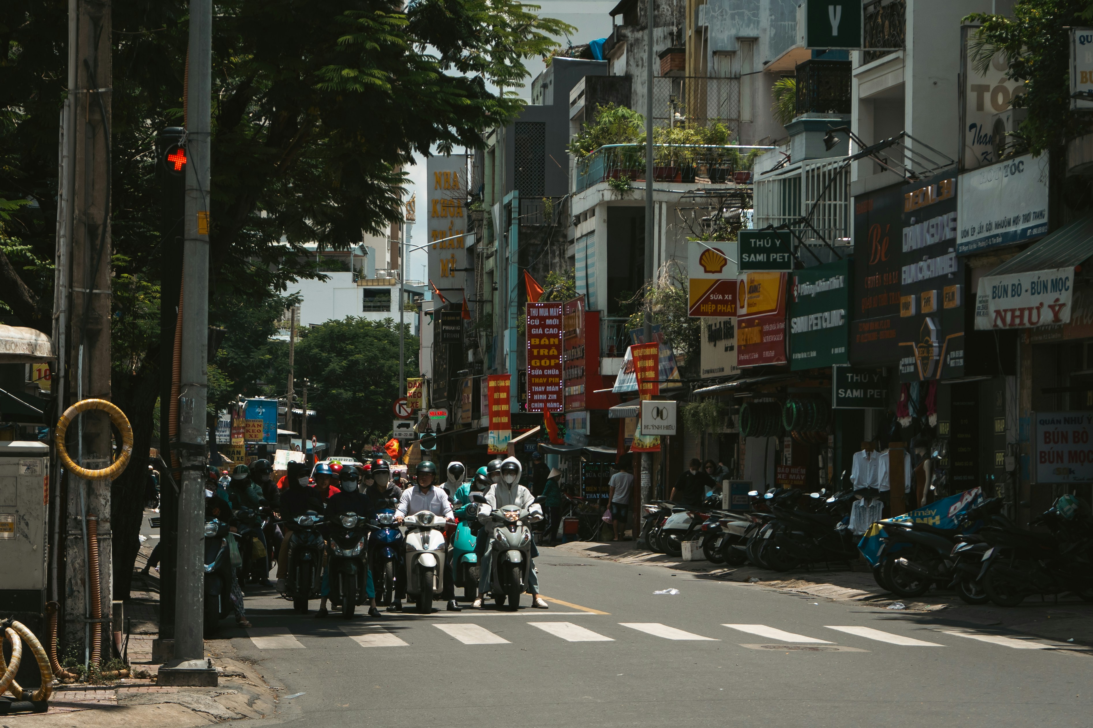 Sepeda motor berbaris di persimpangan jalan kota yang sibuk.