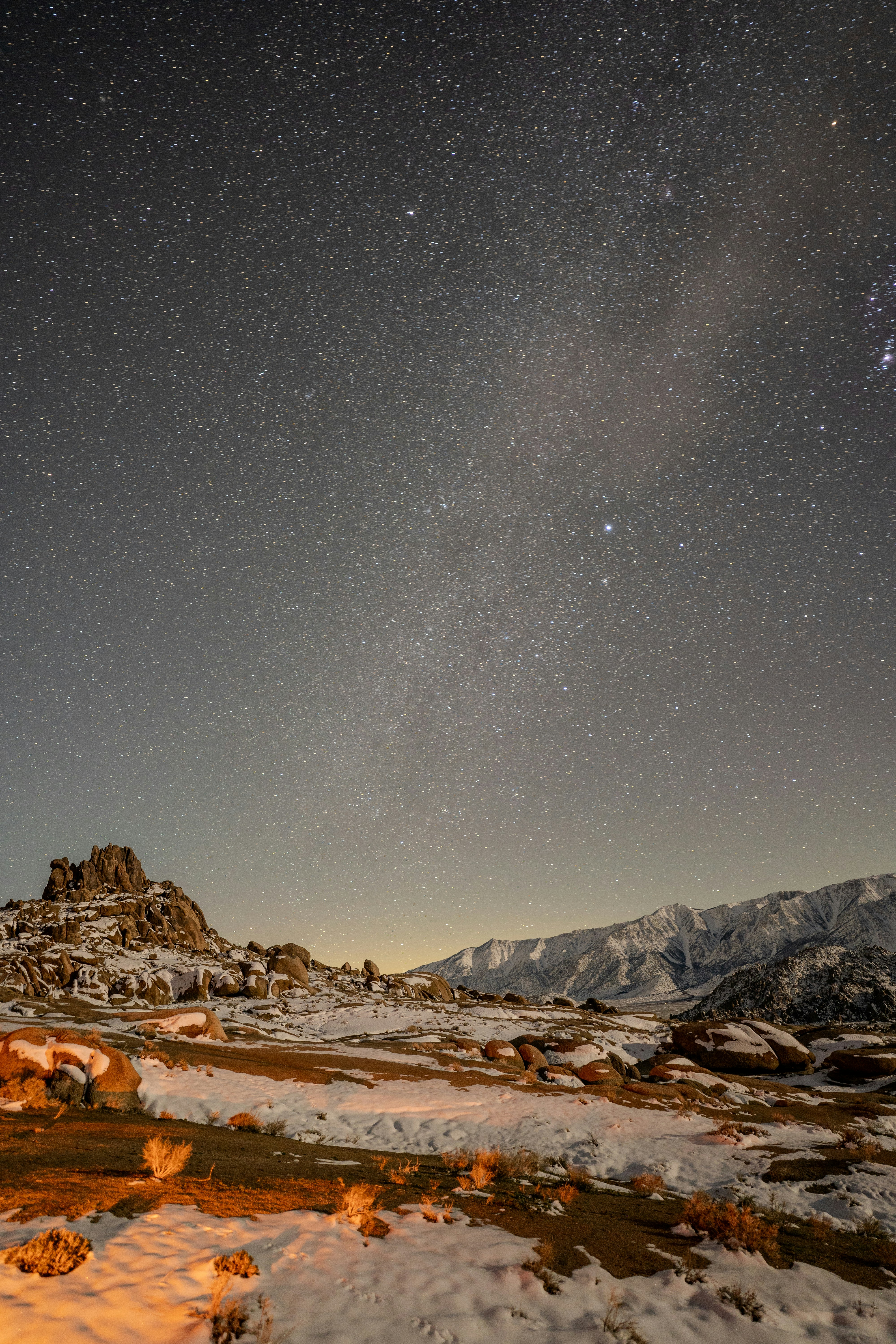 Starry night sky over a snowy mountain landscape