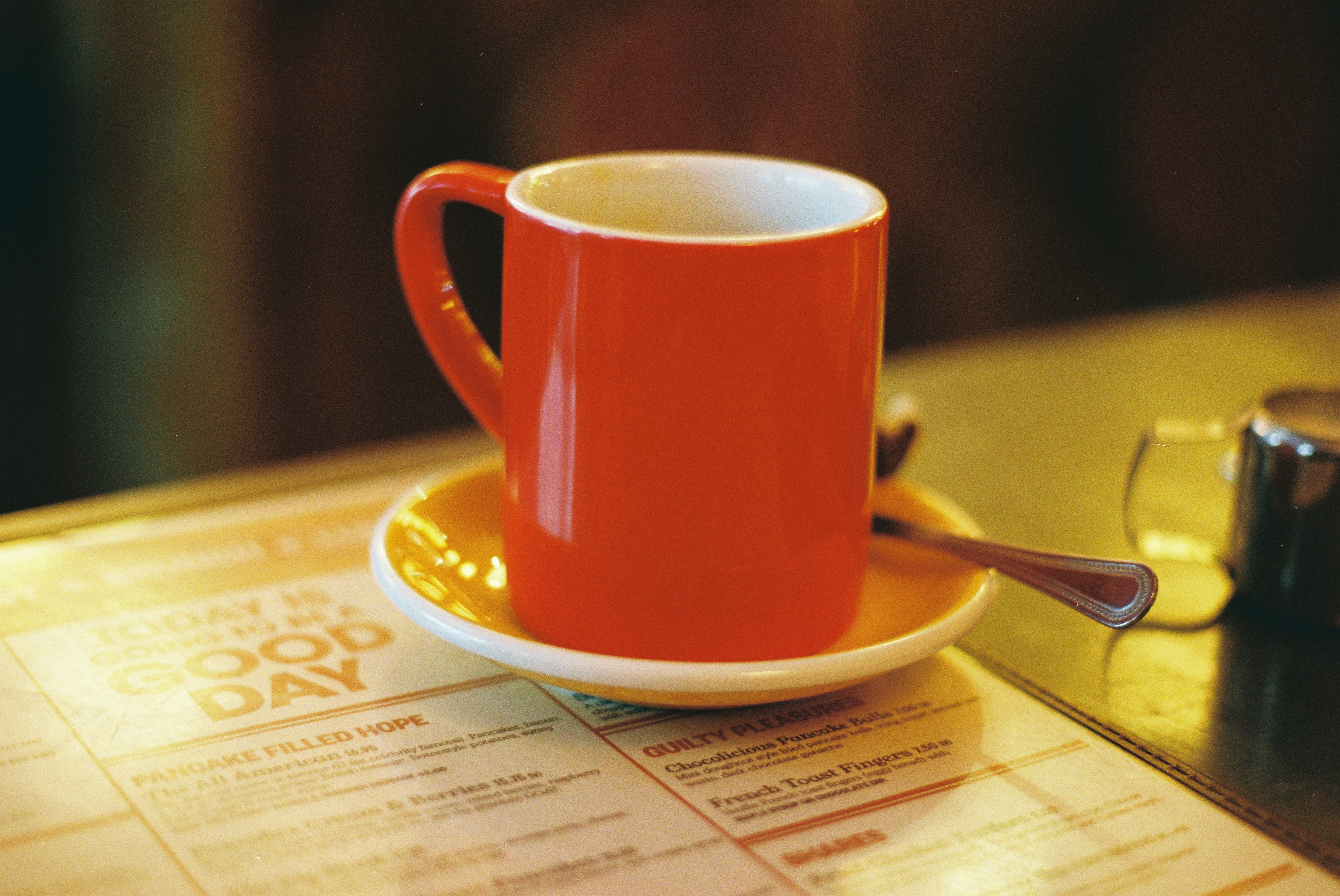 Red coffee cup on a saucer on a cafe table