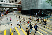 People crossing a busy city street at a crosswalk