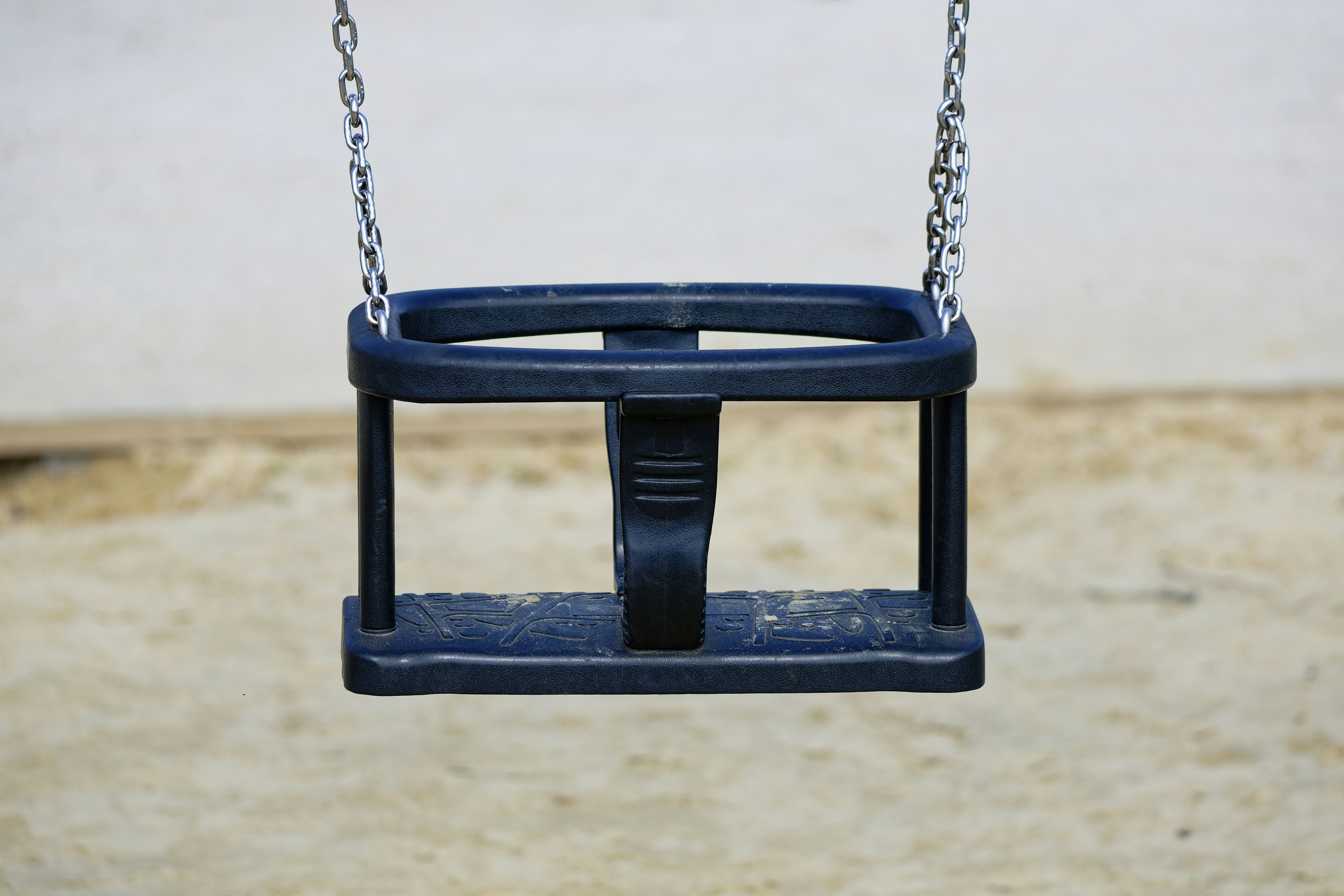 A blue baby swing hanging from chains