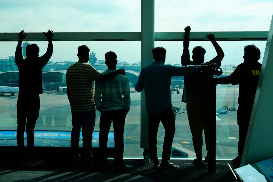 Travellers at an airport window, watching the apron