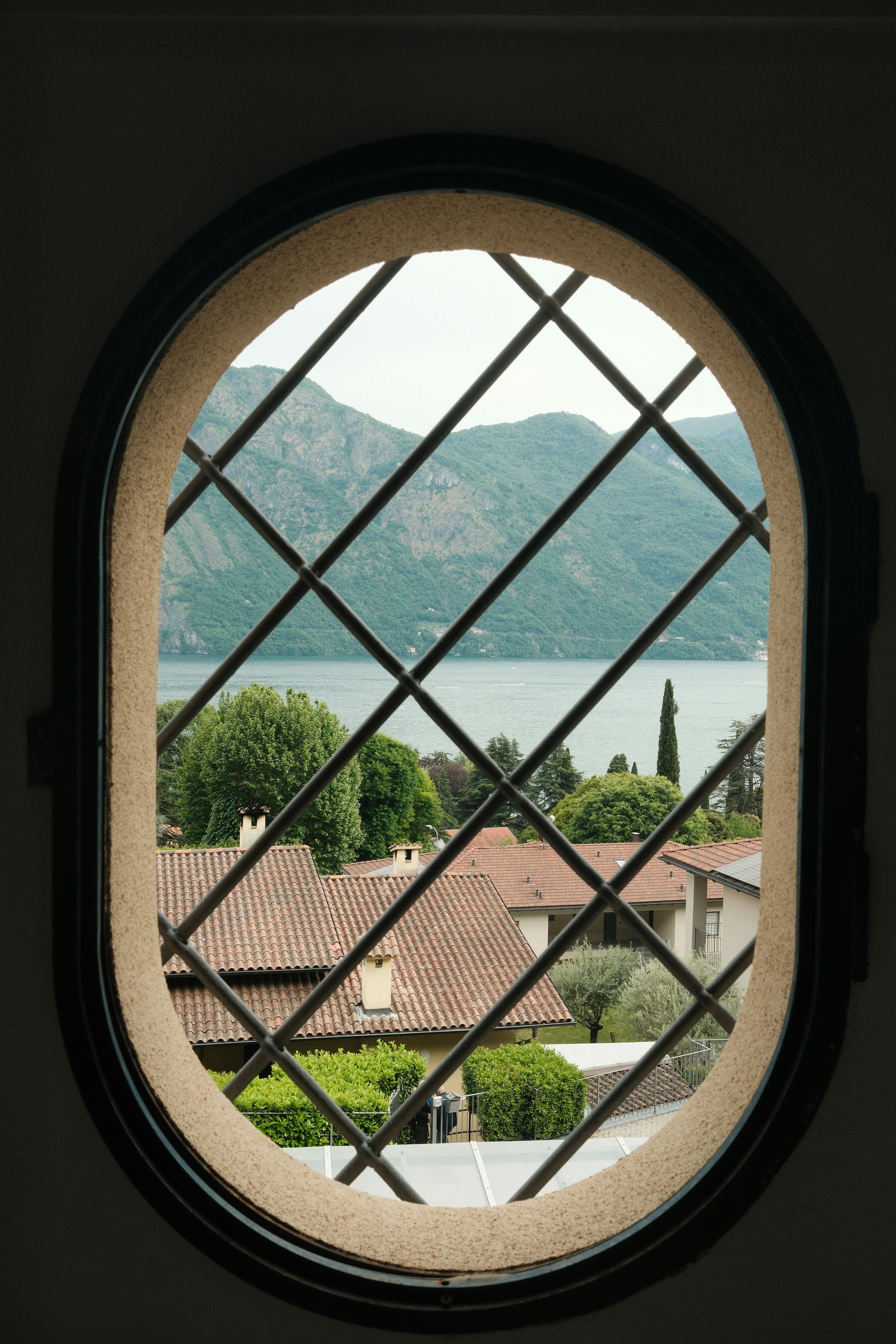 View of lake and mountains through an oval window.