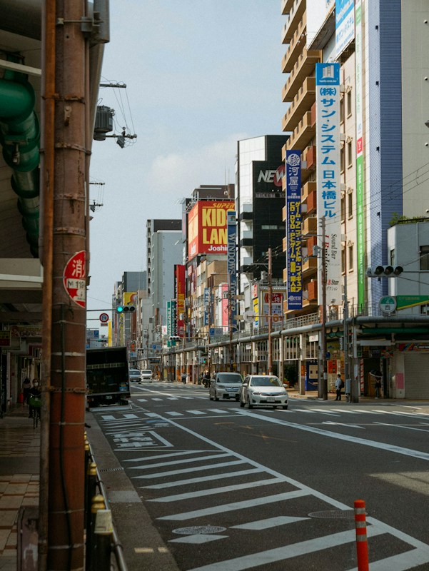 大阪日本橋一帶的商店街道，兩側是招牌林立的大樓