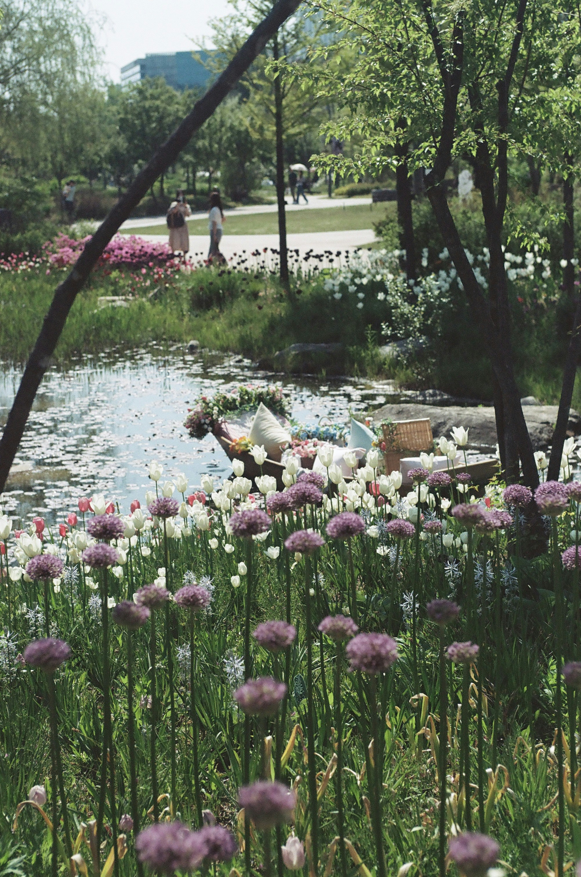 A serene garden with a pond and blooming flowers