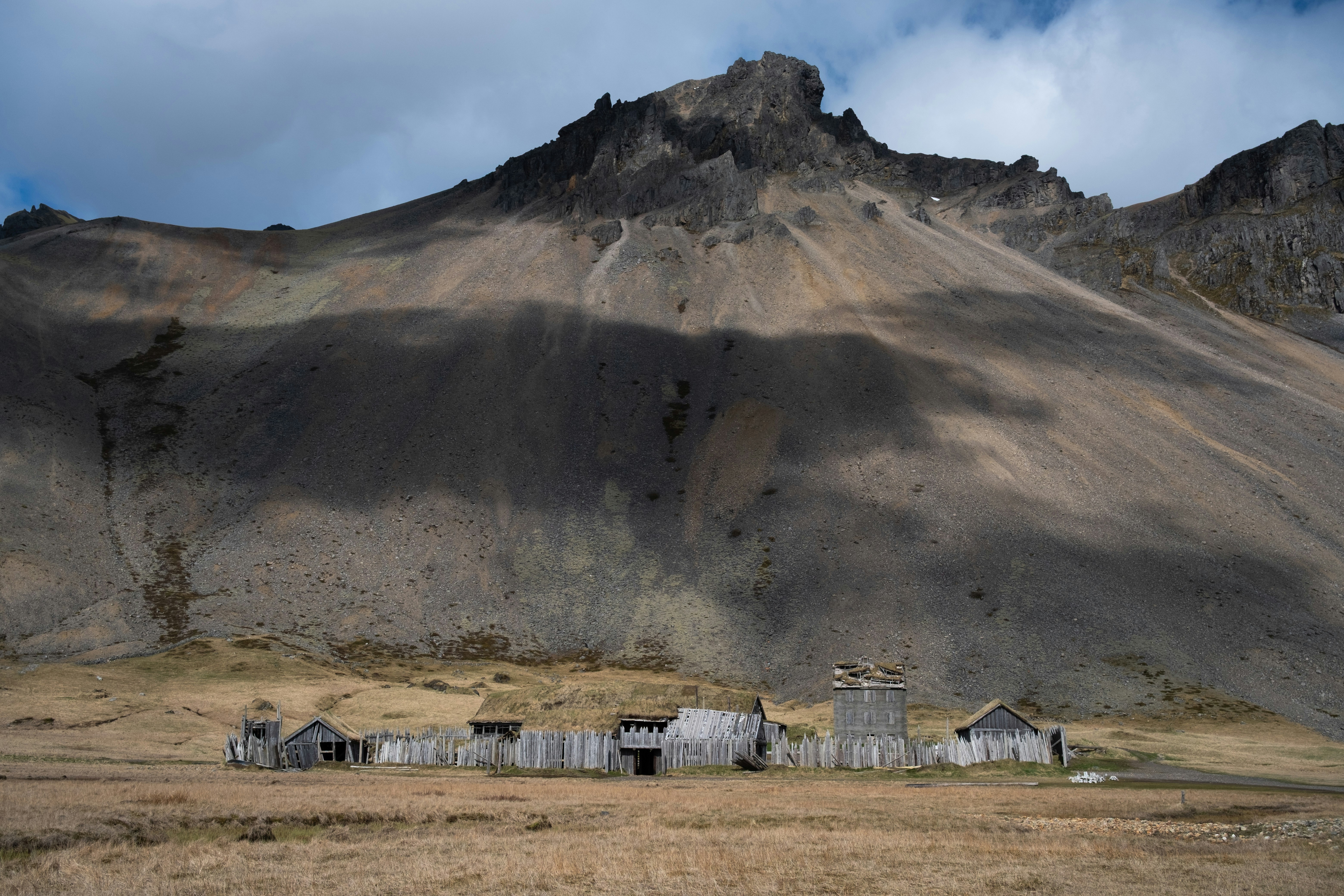 Desa kayu dengan palisade kayu di depan gunung