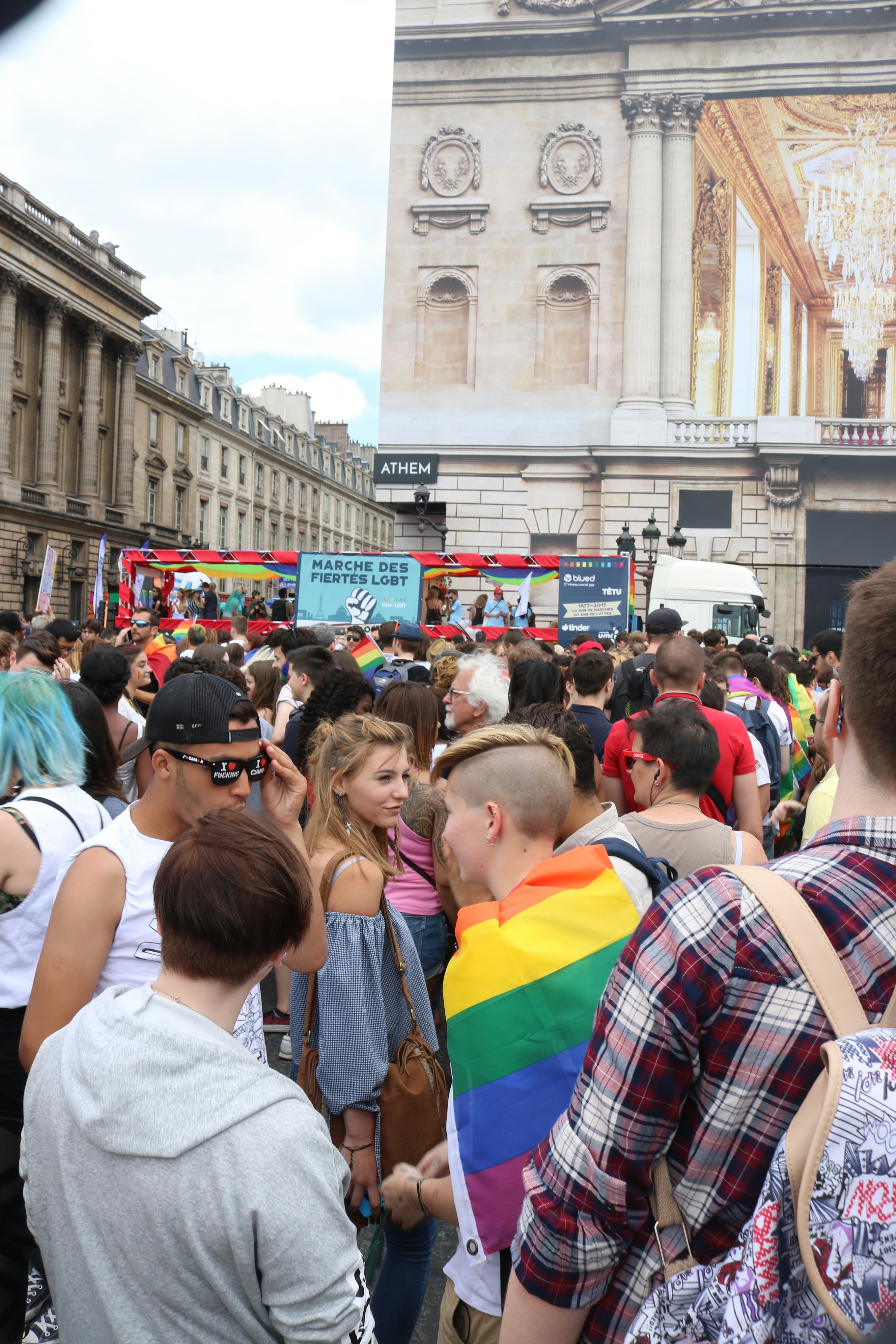 Multidão em um desfile do orgulho com bandeiras arco-íris