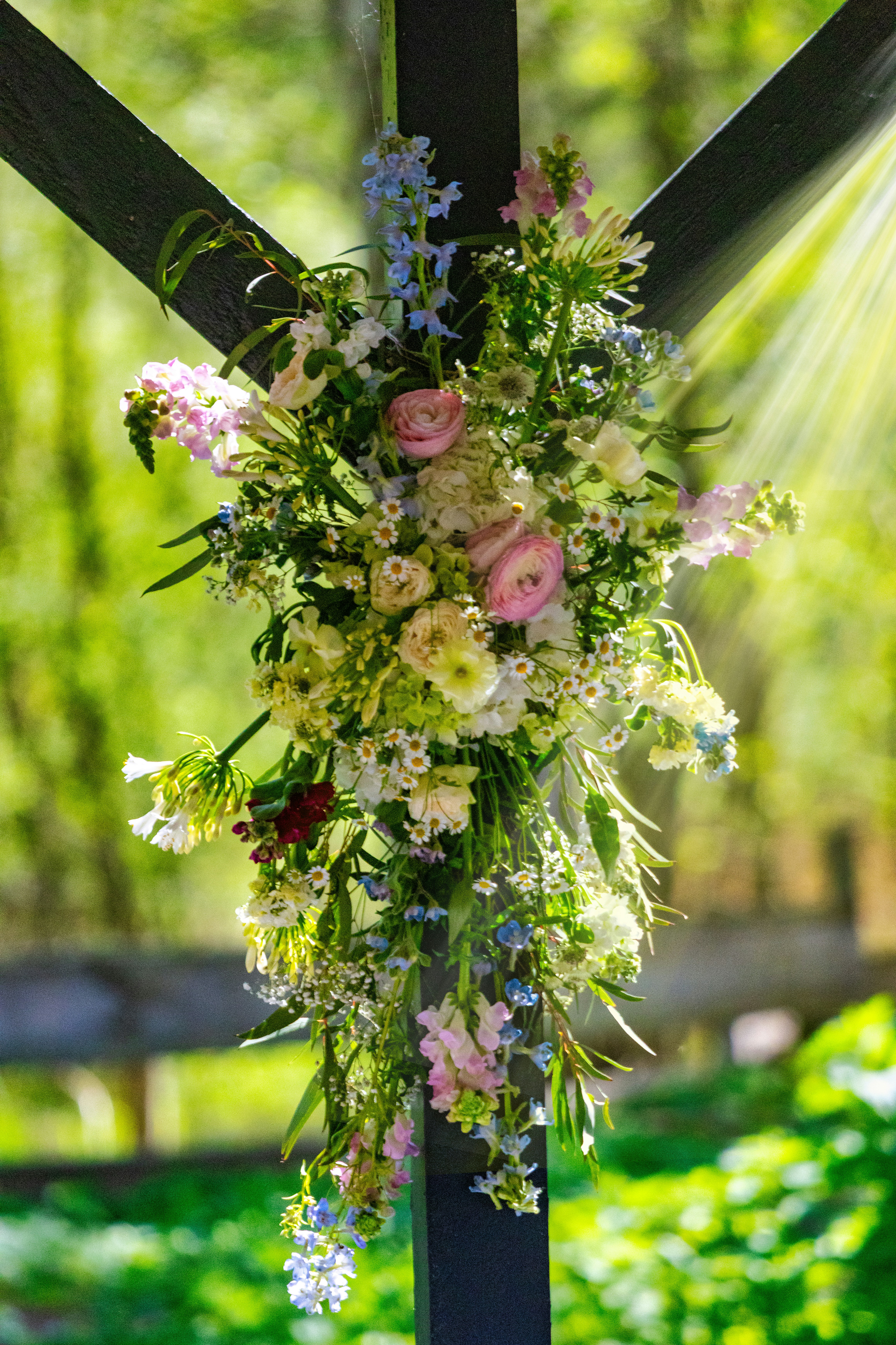 Un hermoso arreglo floral colgado de una estructura de madera.
