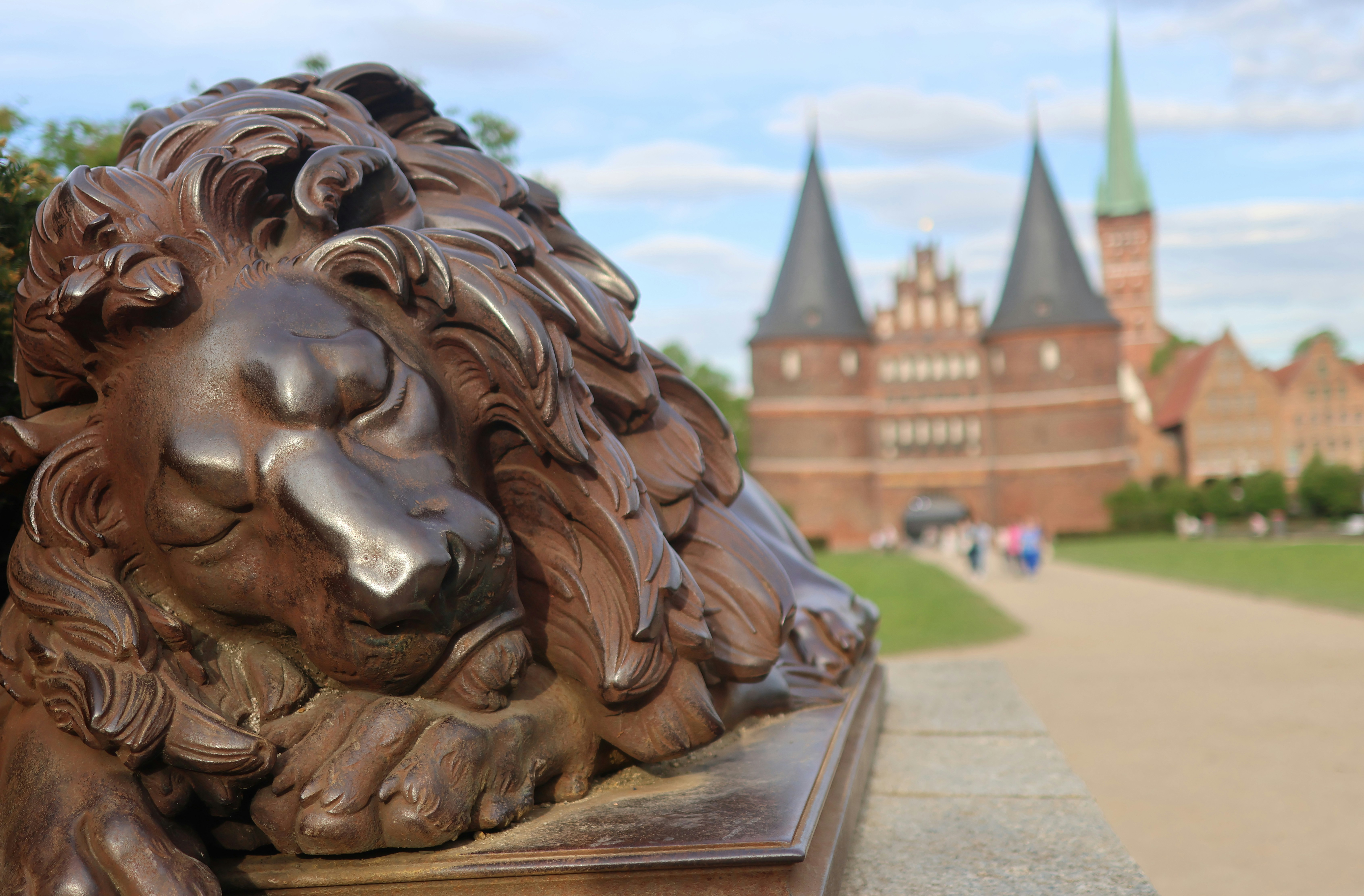 Estatua de león de bronce con edificios históricos en el fondo