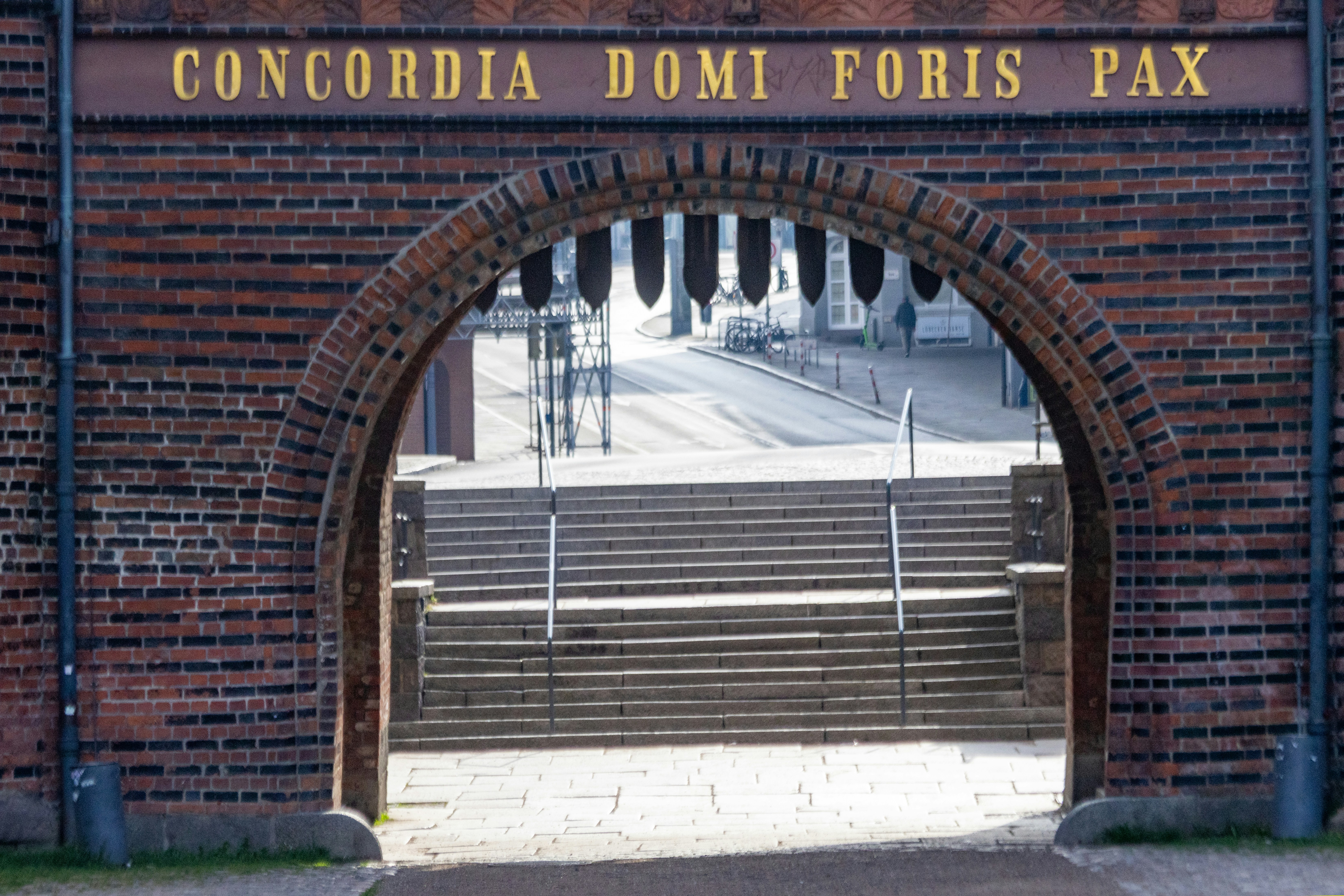 Arco de ladrillo con texto arriba que lleva a las escaleras.