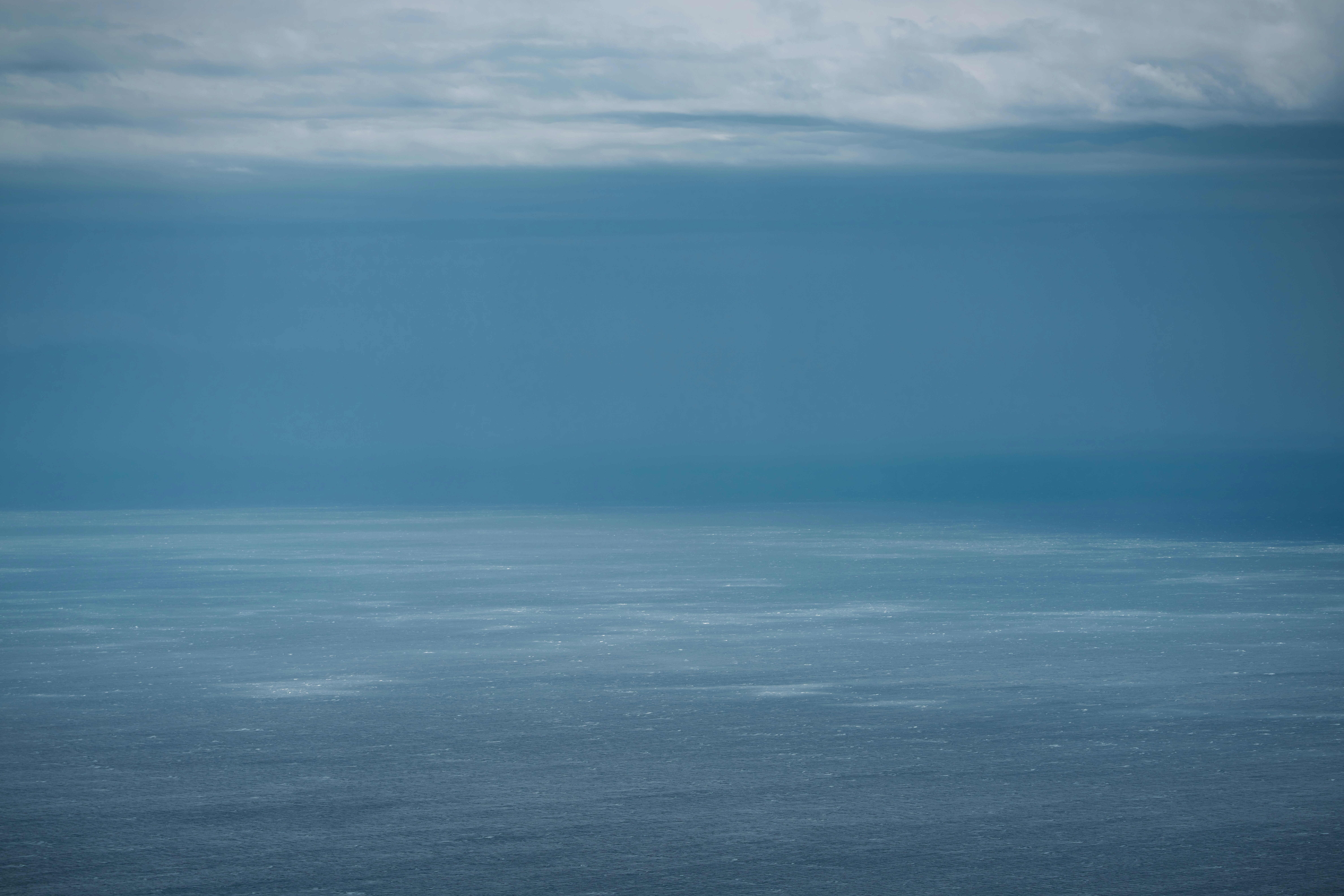 Ruhiges Ozeanwasser unter einem trüben Himmel