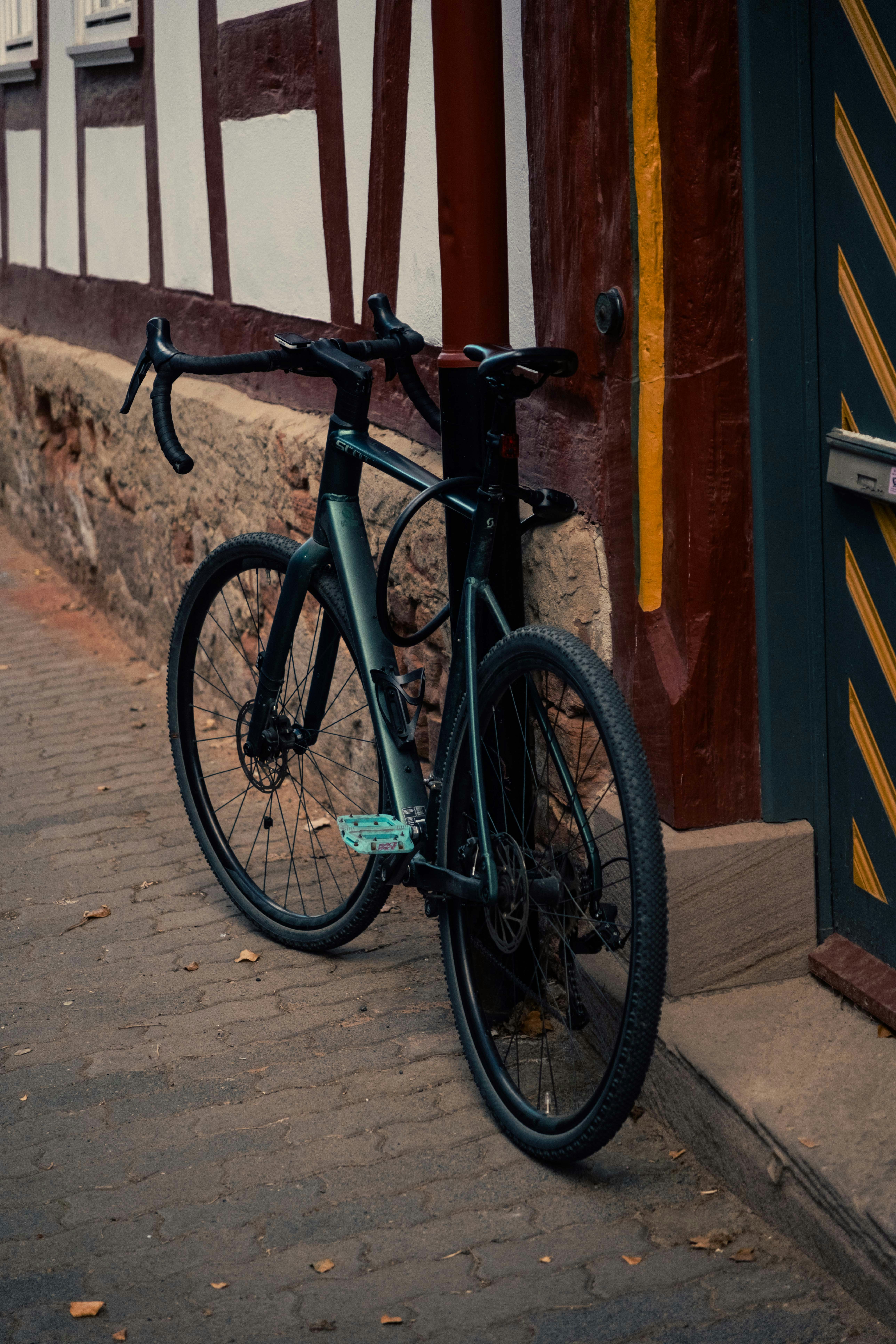 A dark bicycle leans against a historic timber-framed building.