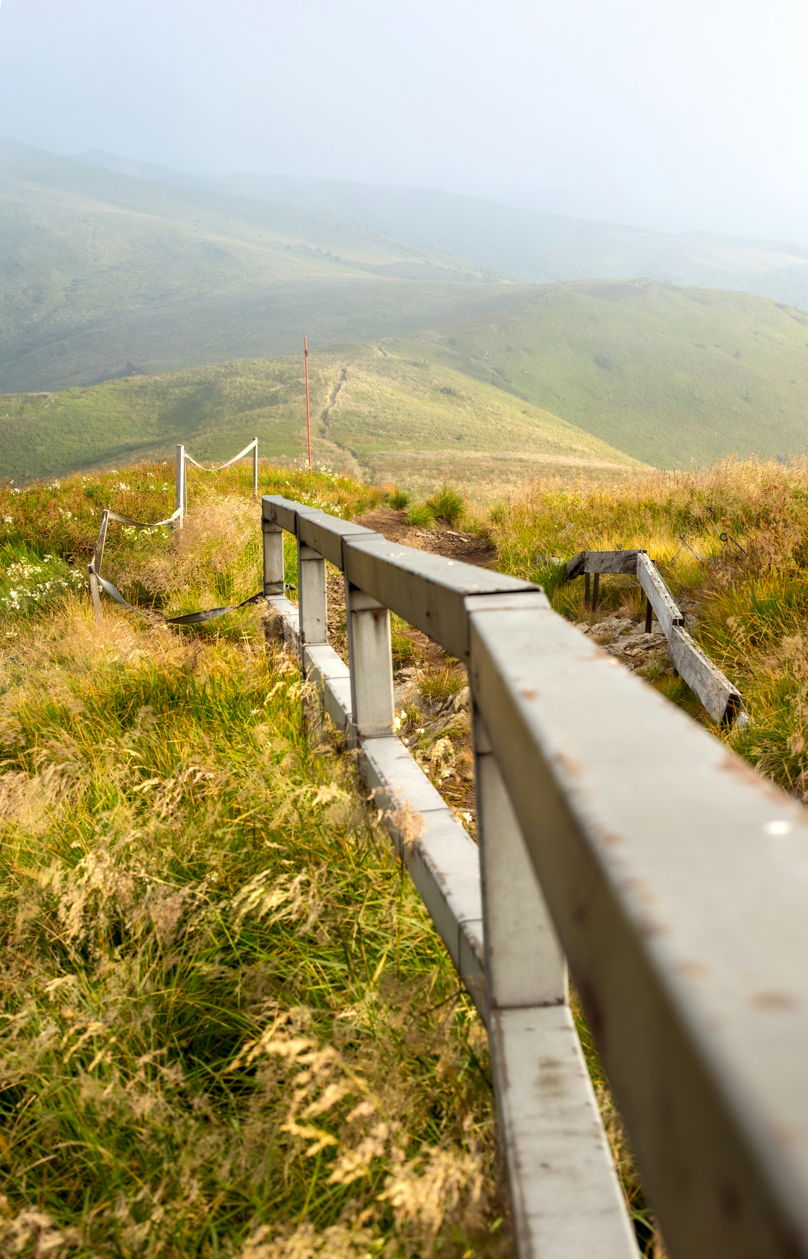 Wooden fence along a grassy mountain path