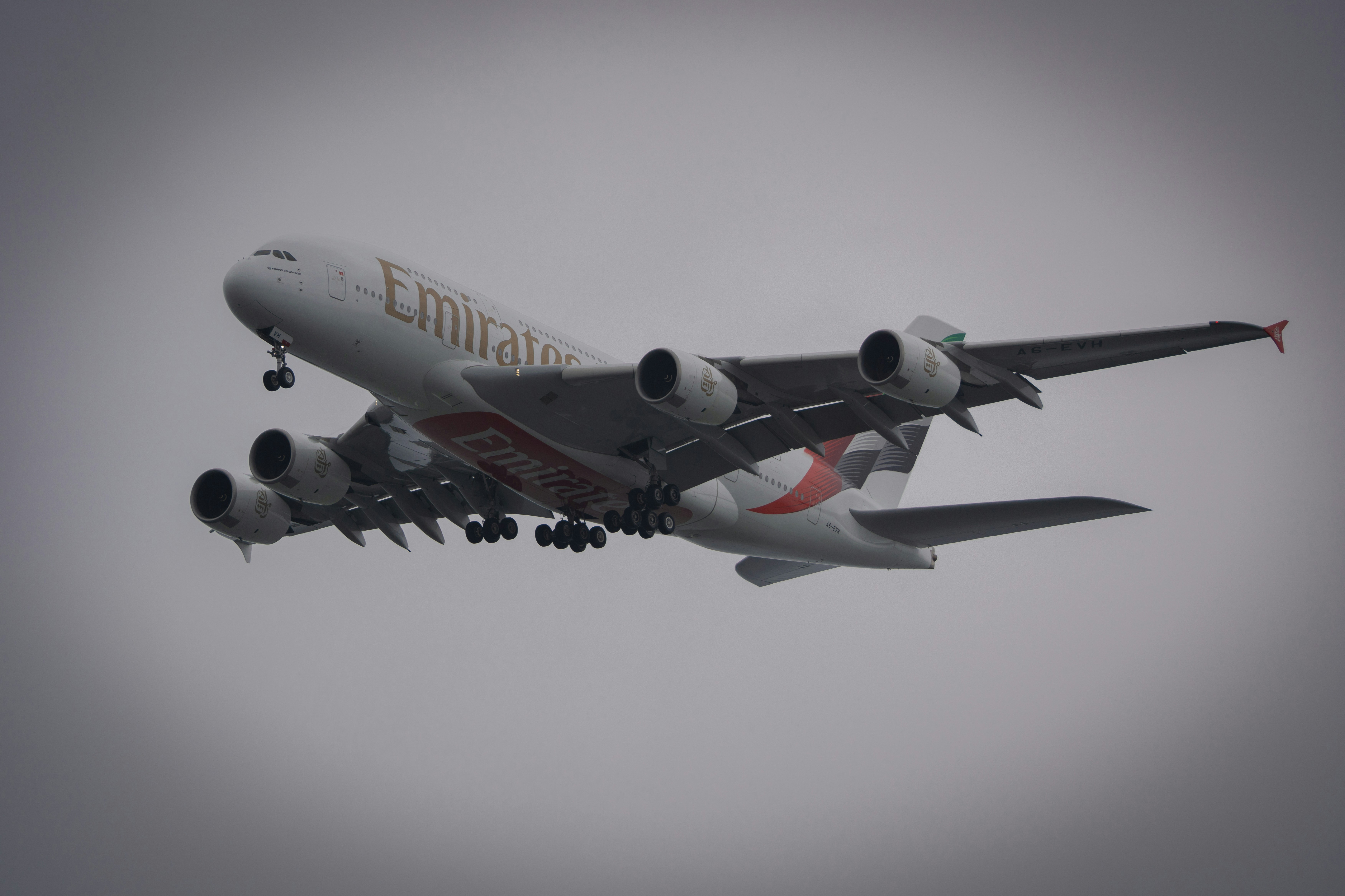Pesawat Emirates lepas landas di langit mendung