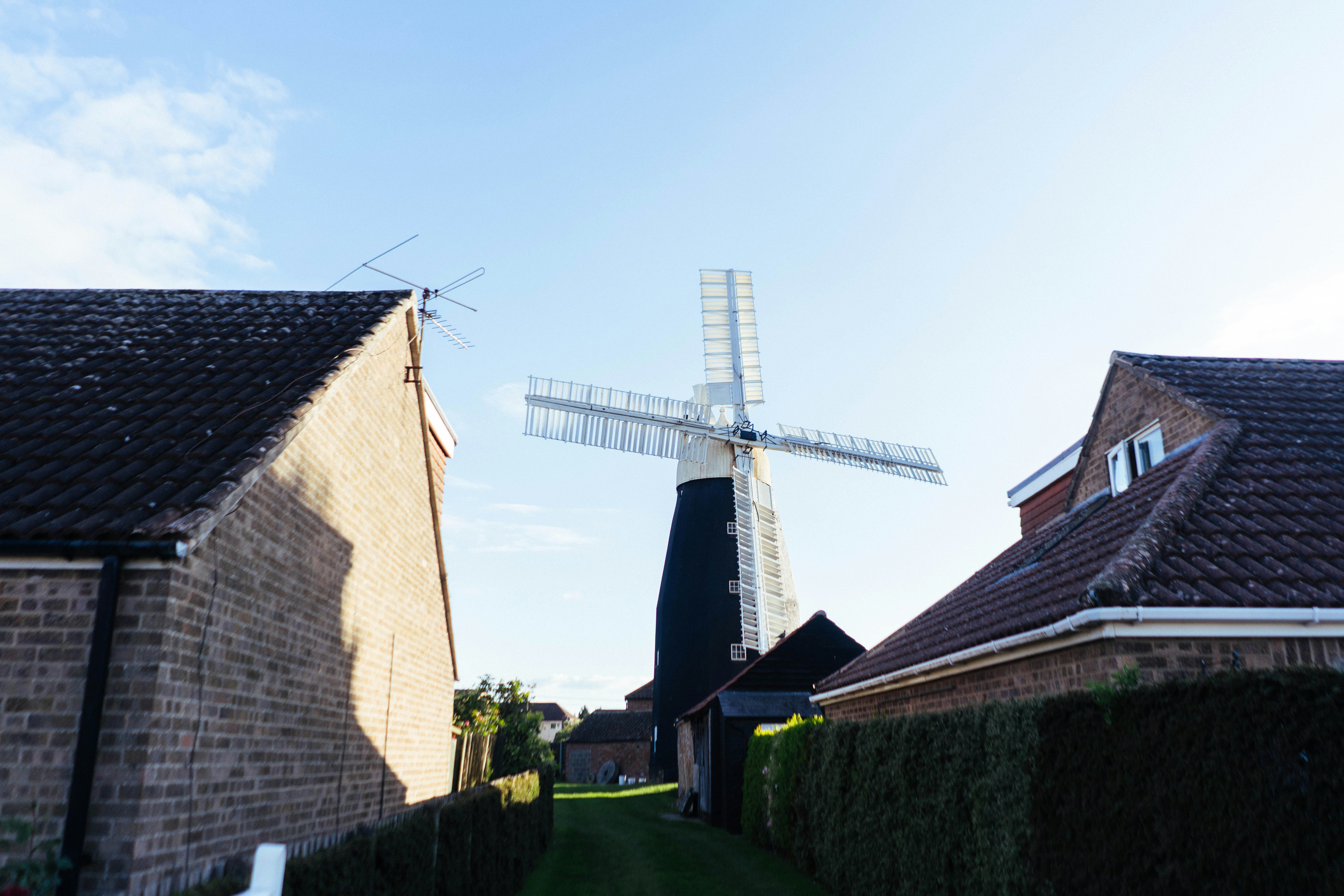 A traditional windmill stands between two houses.