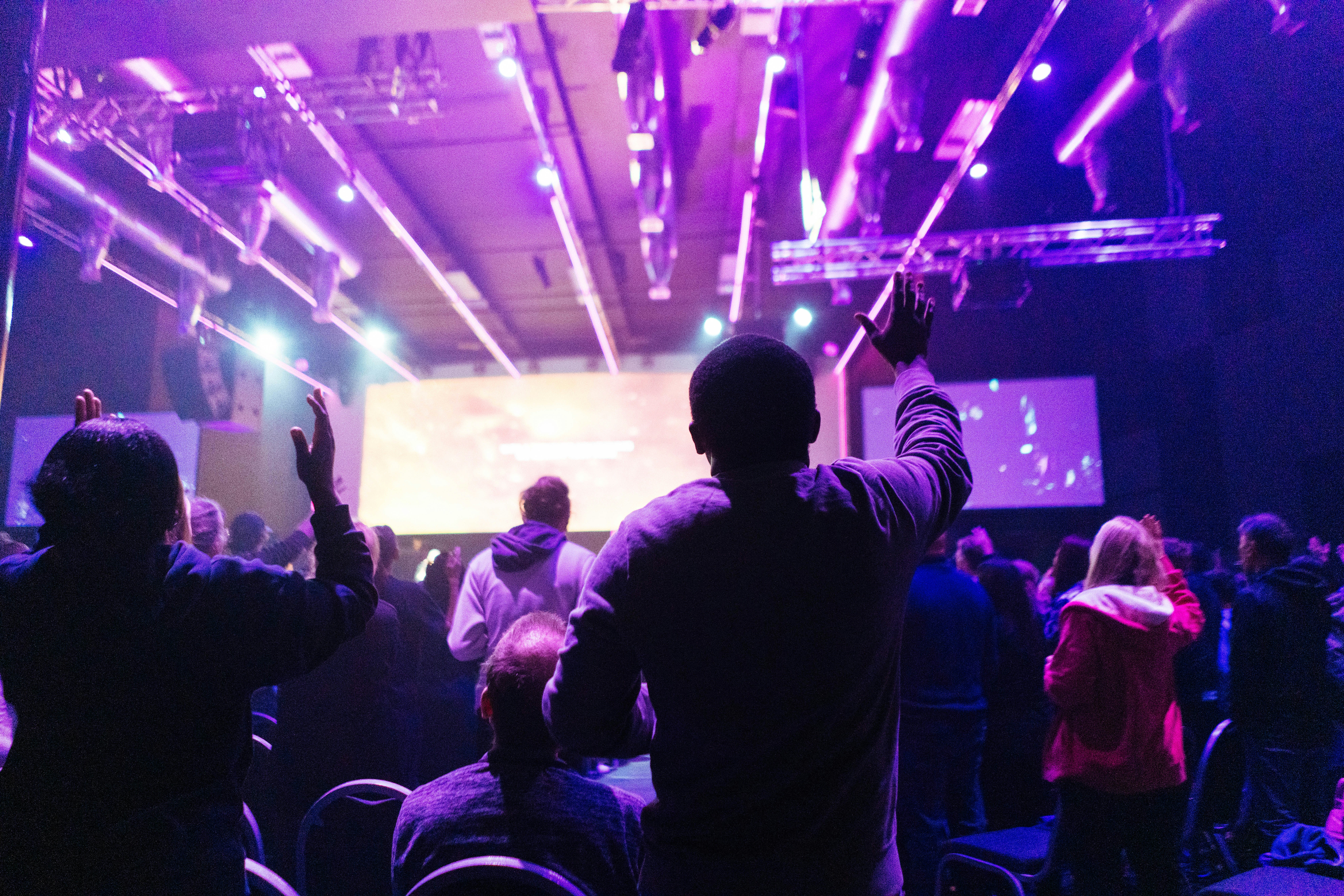 People with hands raised at a concert