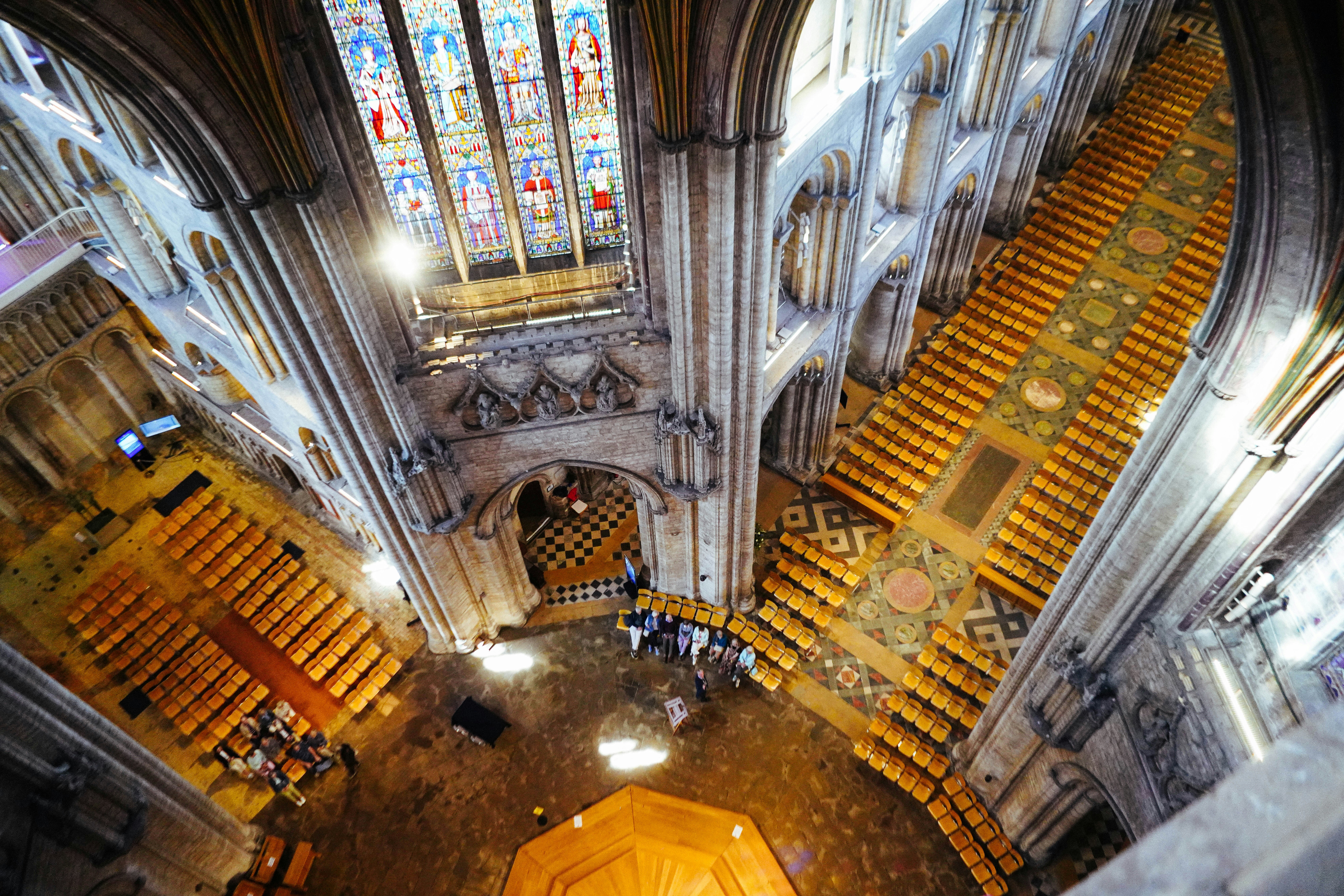 View from above inside a large cathedral with stained glass.