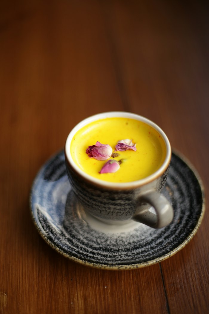 Golden turmeric broth in a rustic ceramic cup