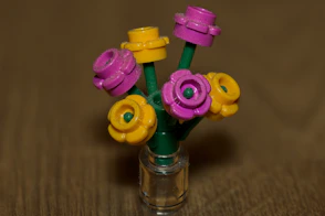 A small vase with colorful lego flowers