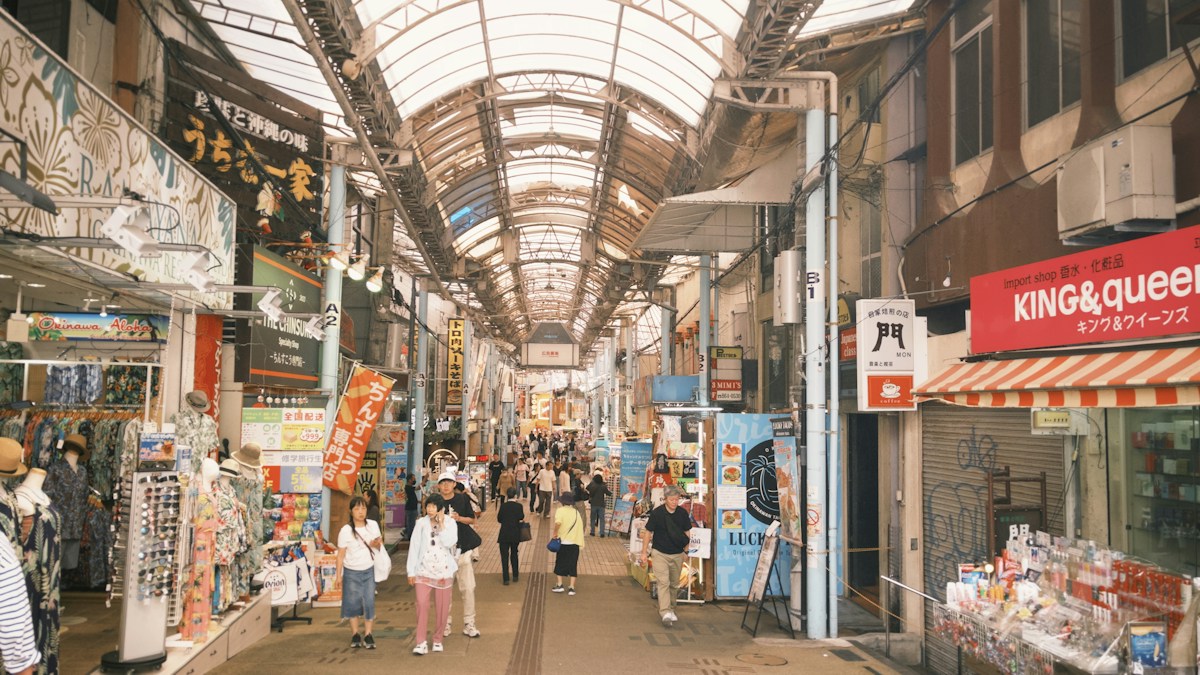 那霸市區有頂棚的商店街，行人在兩側商店之間散步