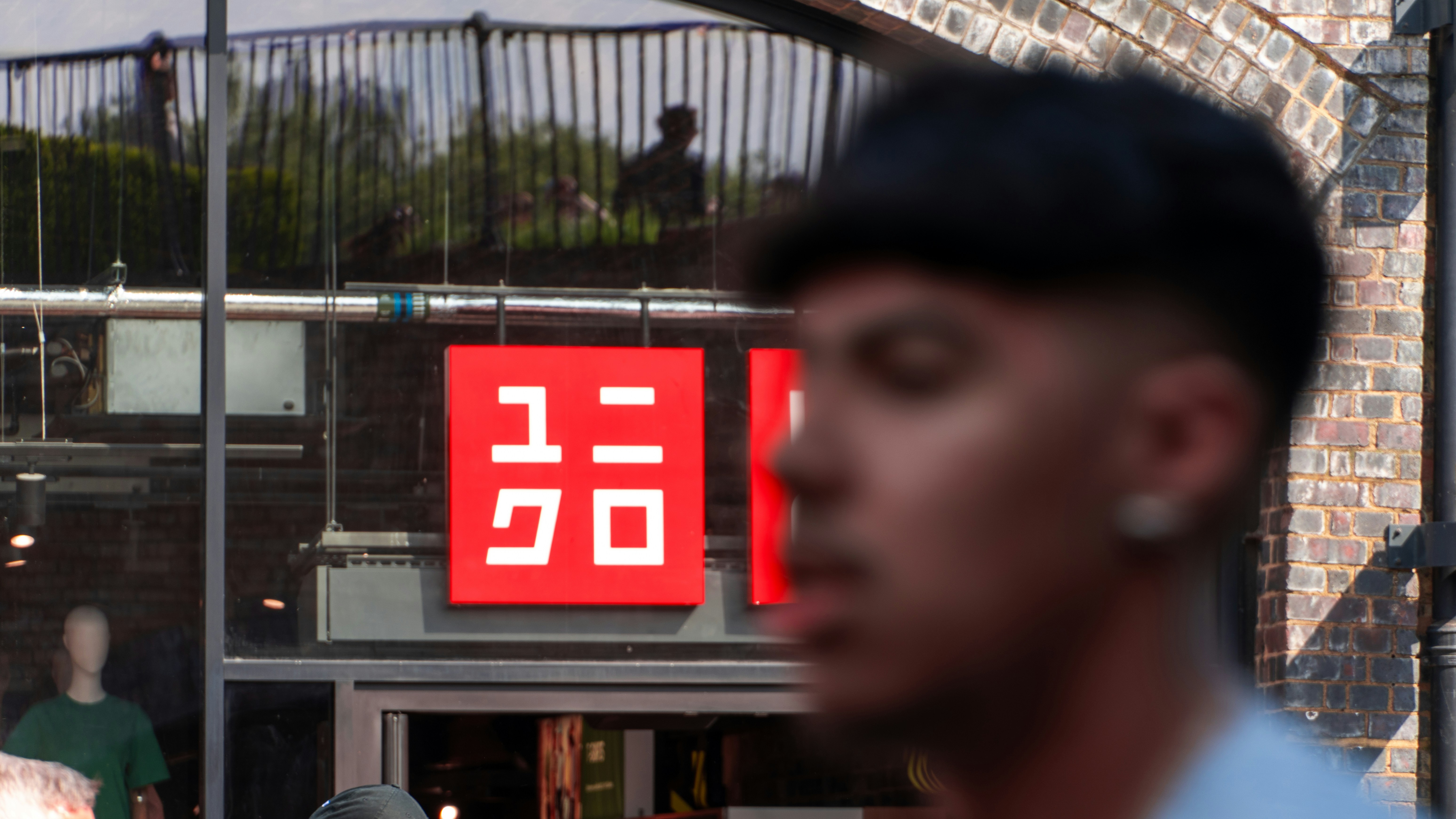 Man walks past a uniqlo store sign