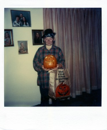 A child in a Halloween costume holding a carved pumpkin and a trick-or-treat bag, ready for a family Halloween event