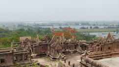 Ancient stone structures with trees and water in background