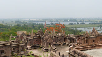 Ancient stone structures with trees and water in background