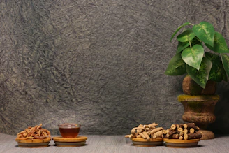 Three wooden bowls of snacks and a cup of tea.